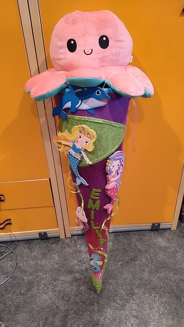 Ein ausgestopfter Oktopus sitzt auf einem lila-rosa Kegel.