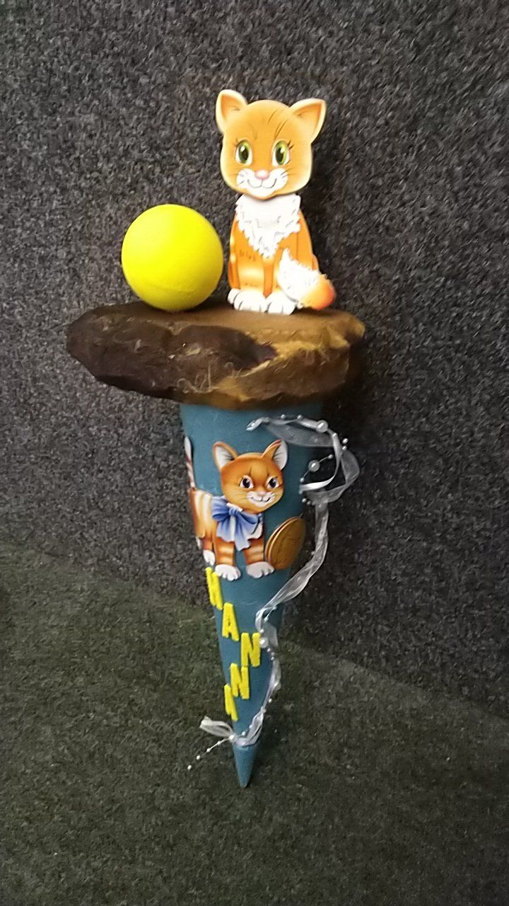 Ein Kegel mit einer Katze und einem Ball darauf