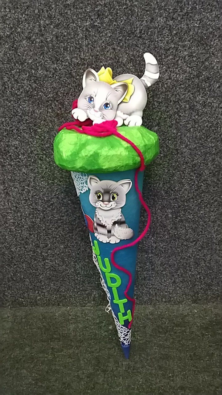 Ein blauer Kegel mit einem Kätzchen darauf.