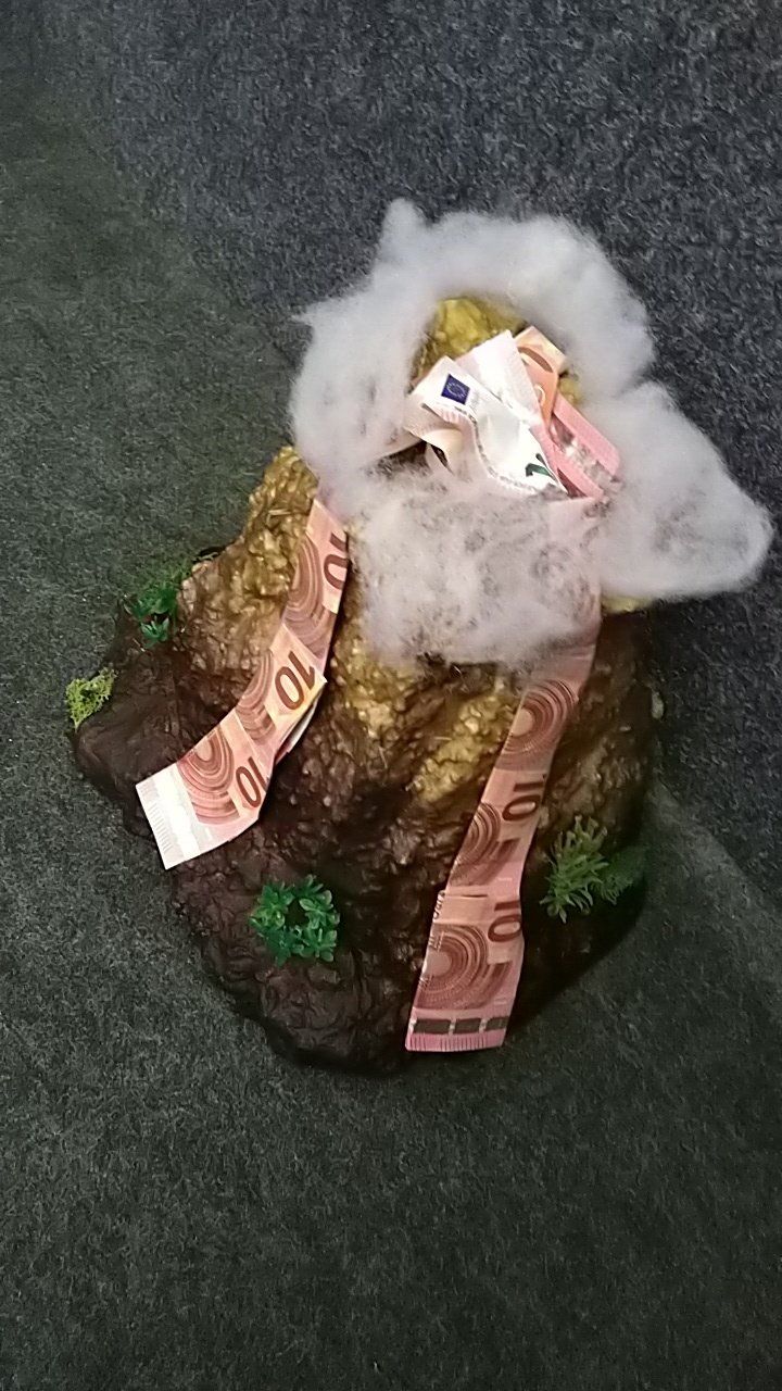 Ein Sack voller Geld liegt auf einem Erdhaufen.