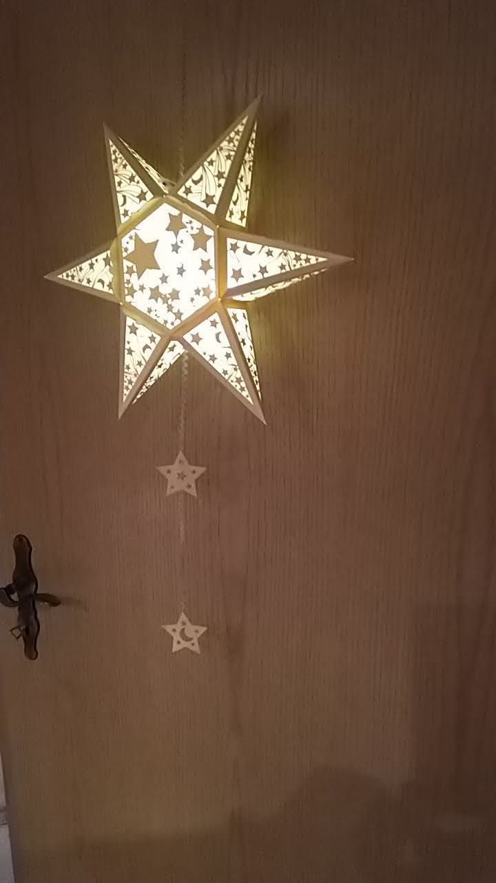 Ein sternförmiges Licht, das neben einem Kreuz von der Decke hängt.