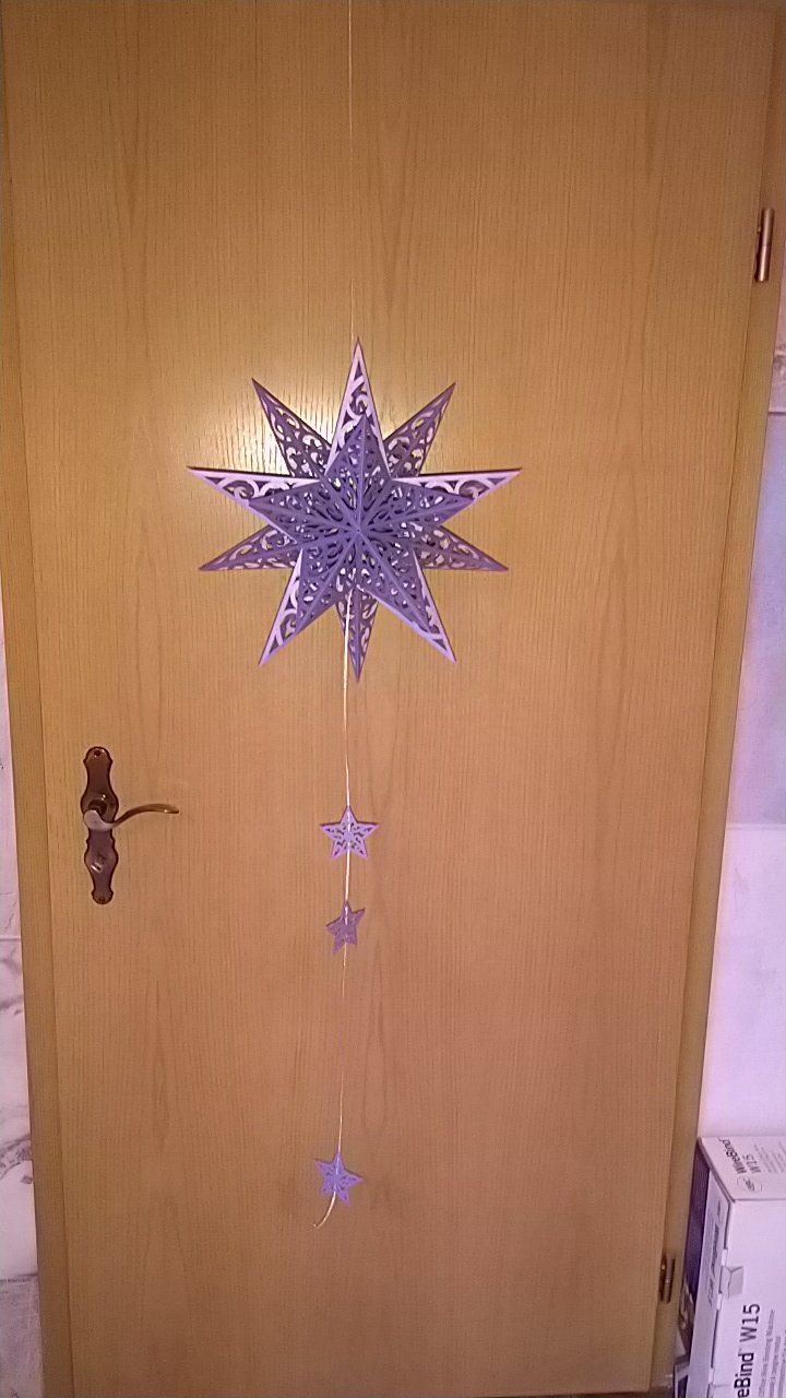 An einer Holztür hängt ein Weihnachtsstern.