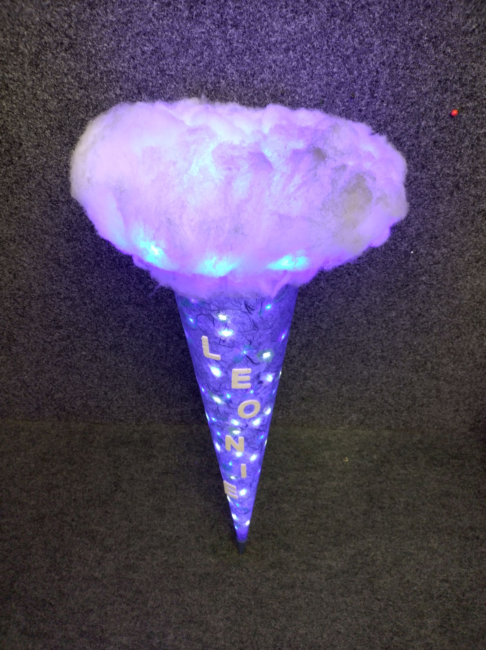 Eine lila Zuckerwatte-Tüte mit dem Buchstaben L darauf