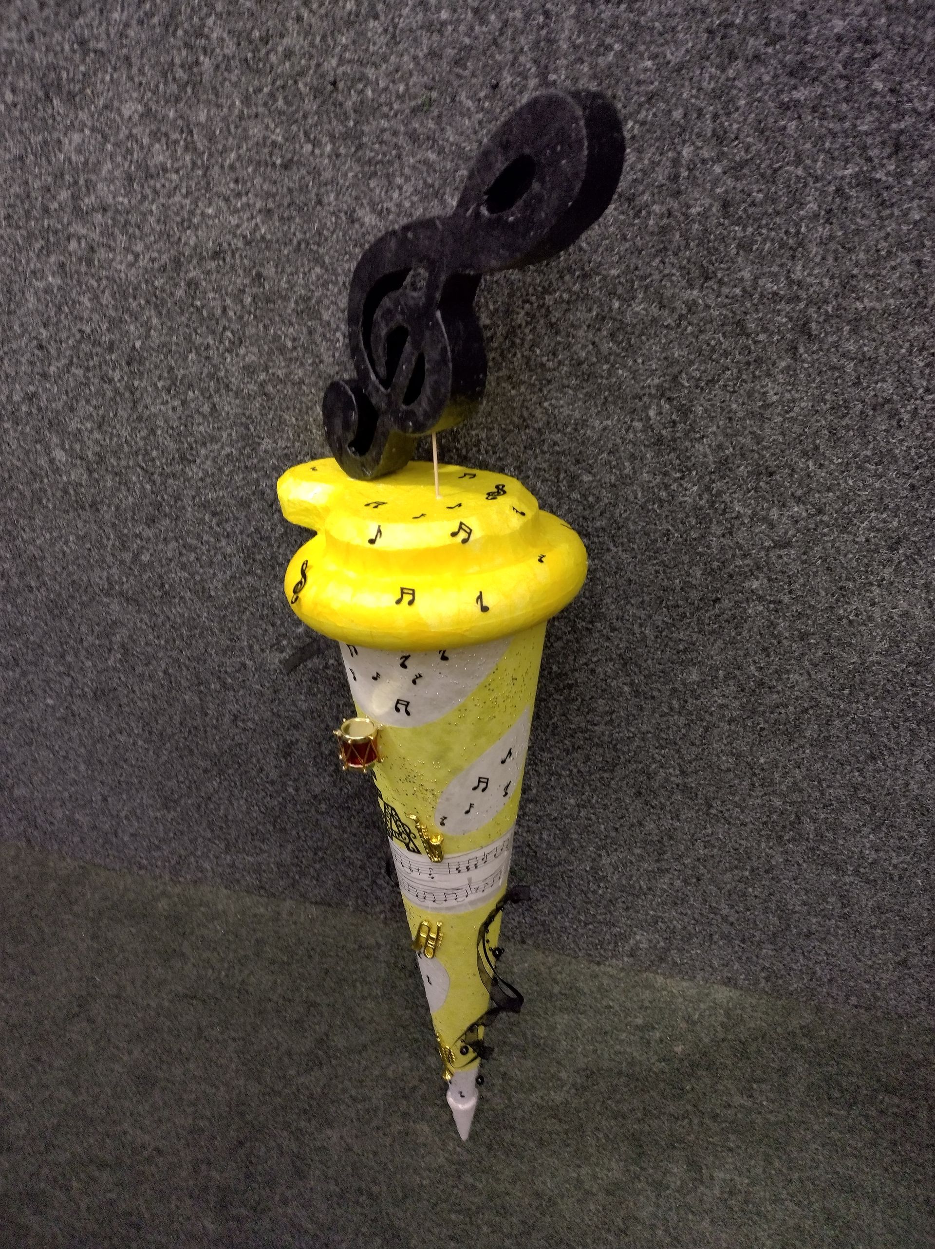 Eine gelb-weiße Eistüte mit einer schwarzen Schlange obenauf