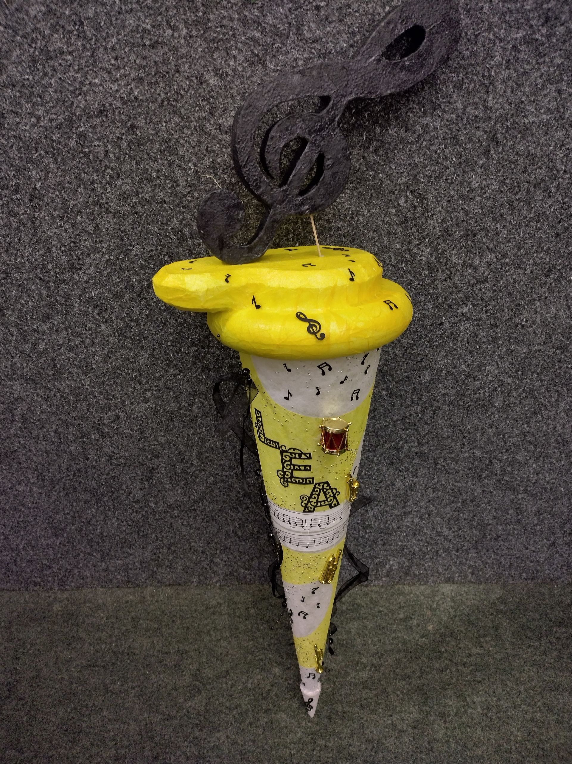 Eine gelb-weiße Eistüte mit einer Schlange darauf.