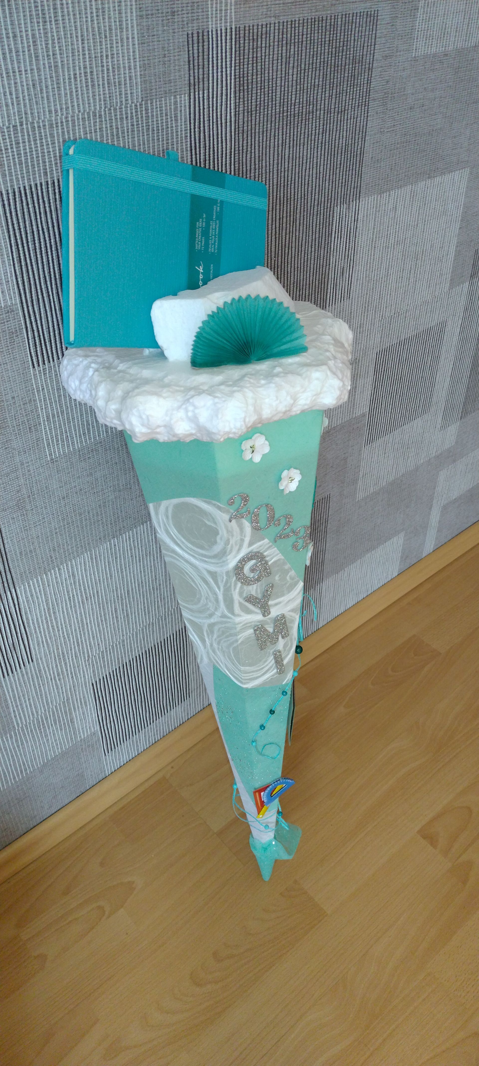 Ein grüner Kegel liegt auf einem Holzboden neben einer Wand.