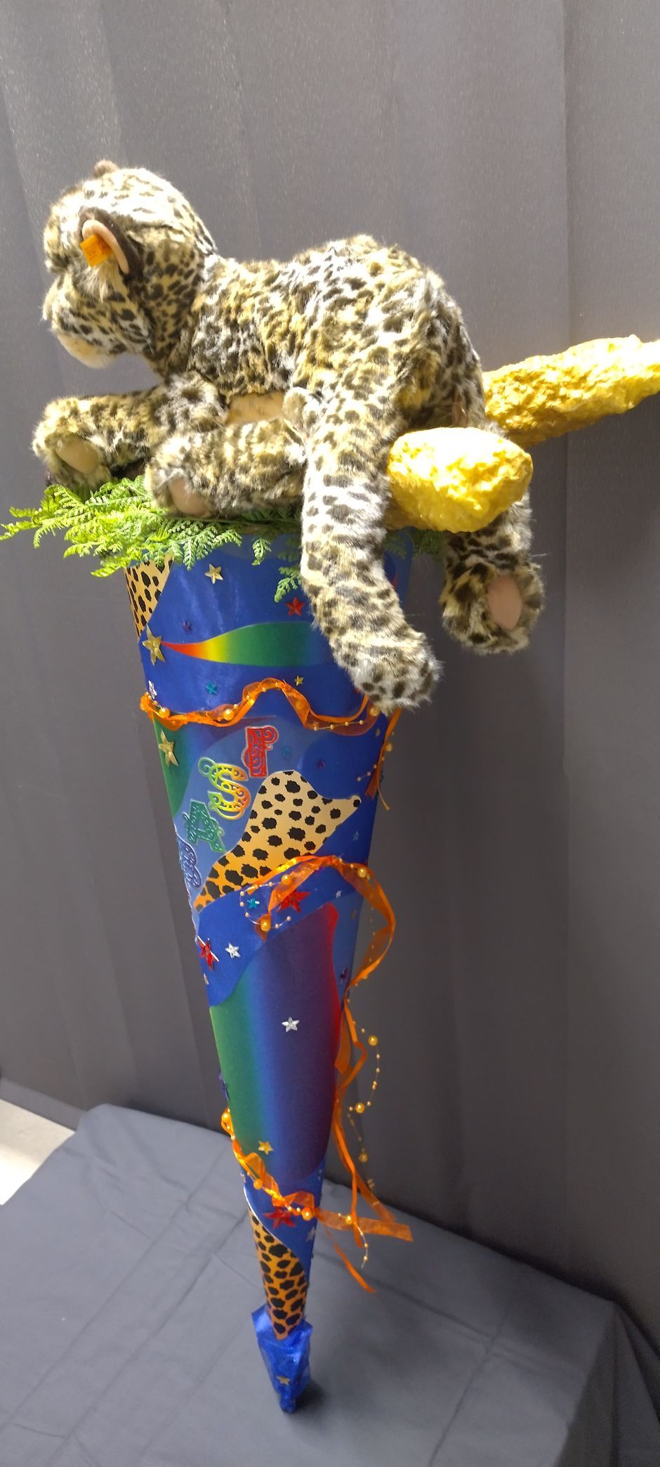Ein ausgestopfter Leopard sitzt auf einem bunten Kegel