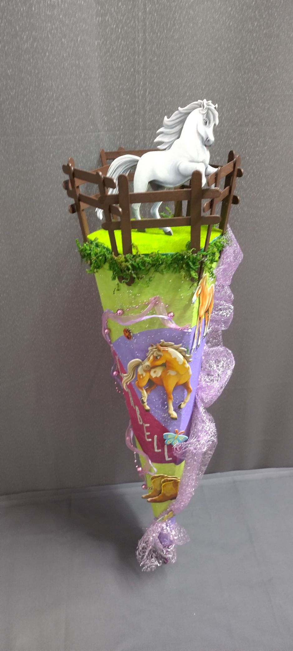 Ein Kegel mit einem Pferd und einem Zaun darauf.