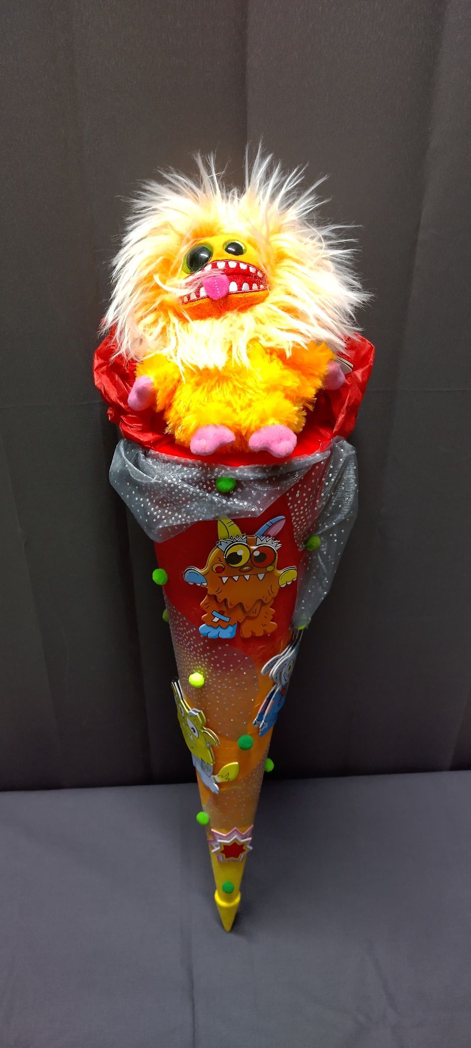 Ein Stofftier sitzt auf einem Kegel.