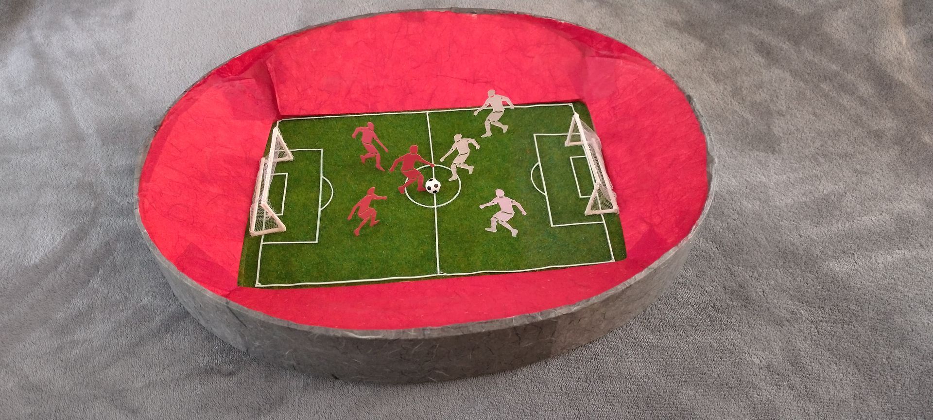 Ein Modell eines Fußballfeldes mit Spielern darauf