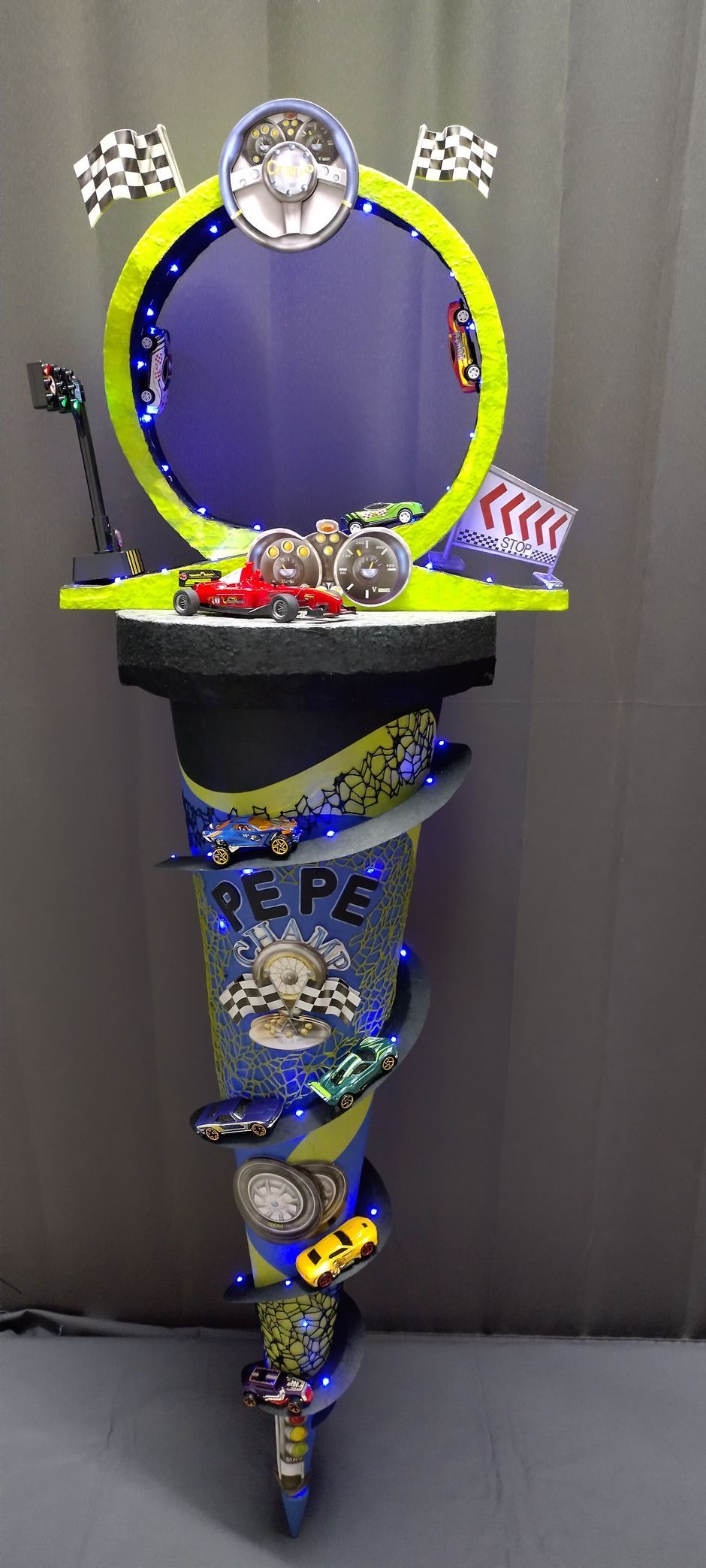 Ein Kegel voller Autos und einem Spiegel darauf.