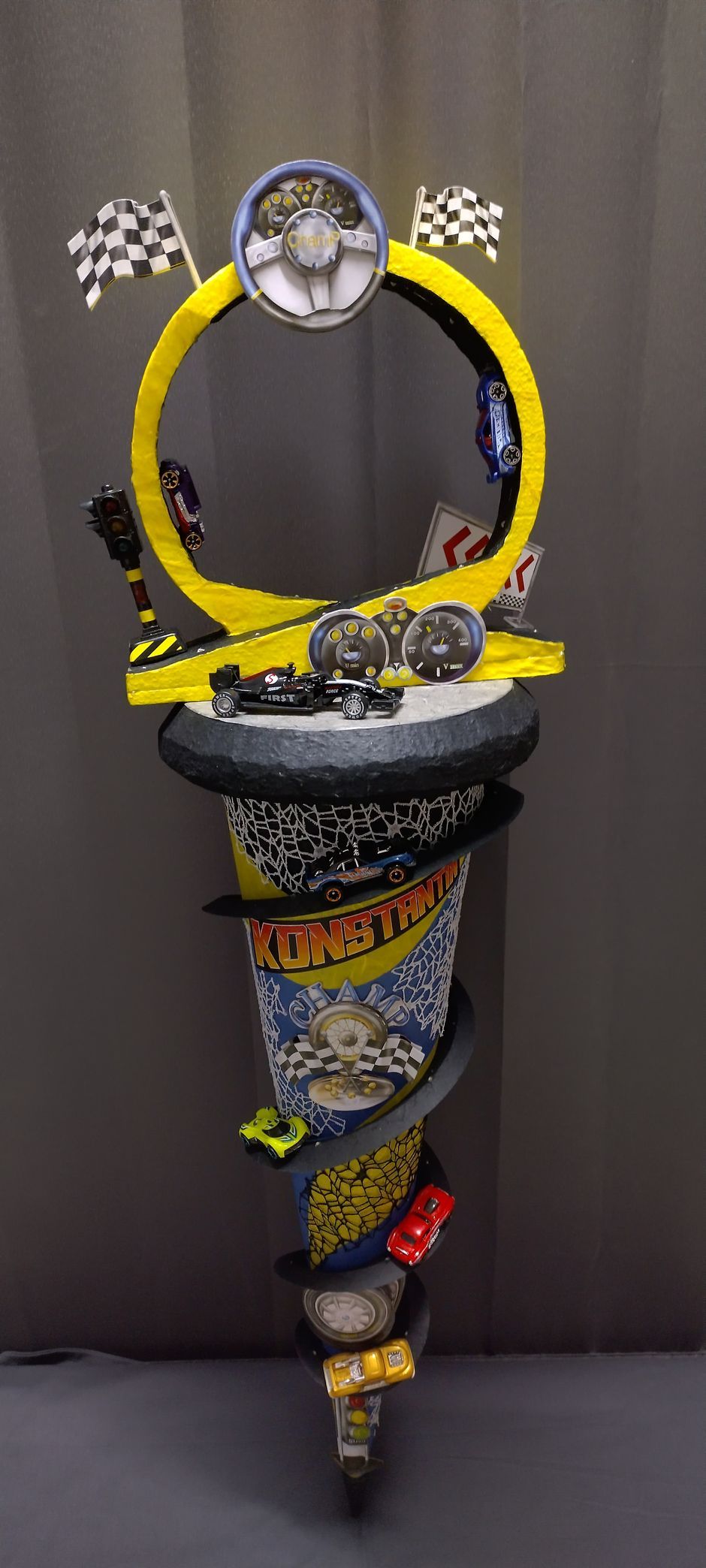 Auf einem Tisch steht die Skulptur einer Hot-Wheels-Rennstrecke mit Autos darauf.