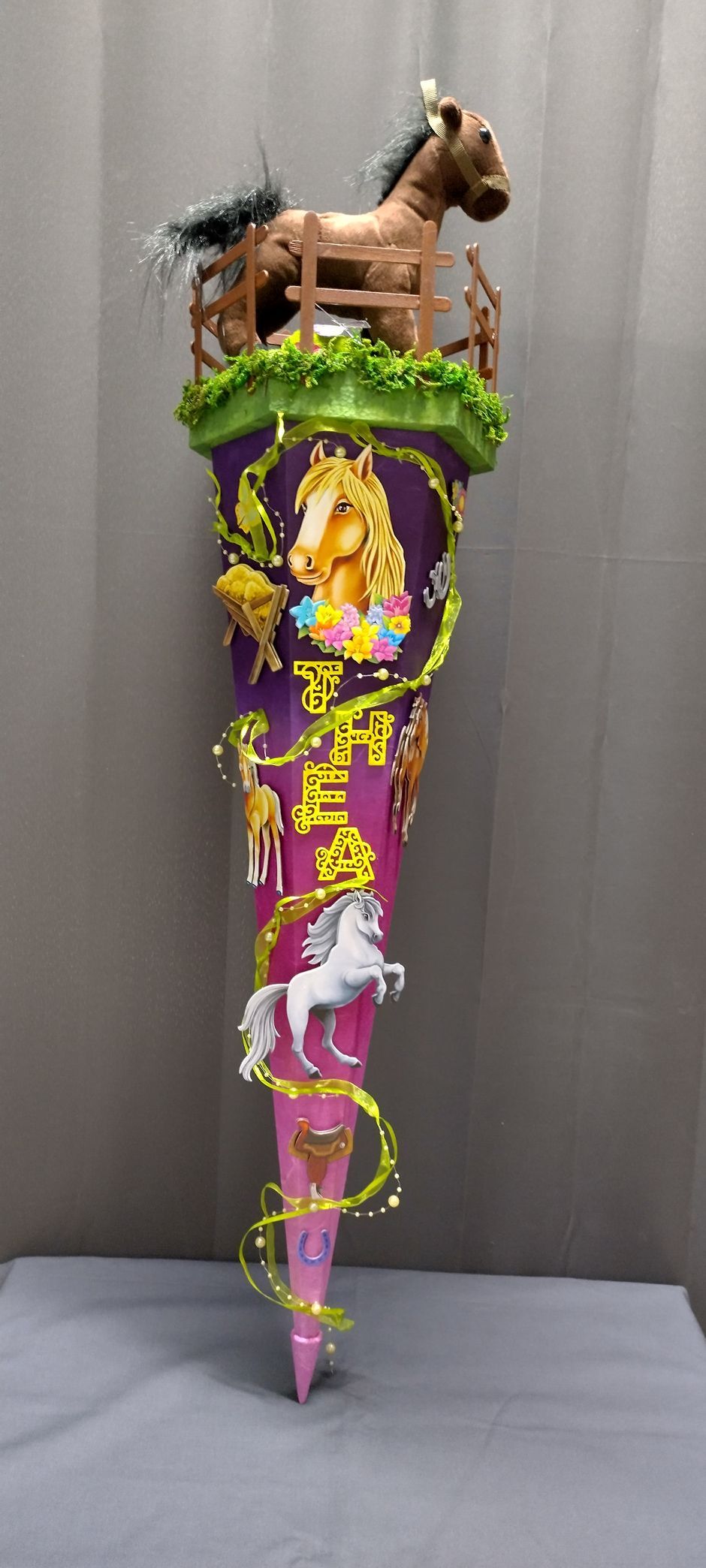 Ein rosa und lila Kegel mit einem Pferd darauf.
