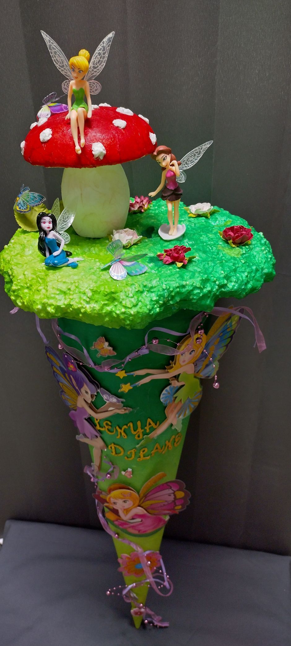 Ein Cupcake mit einer Tinkerbell, die auf einem Pilz sitzt.