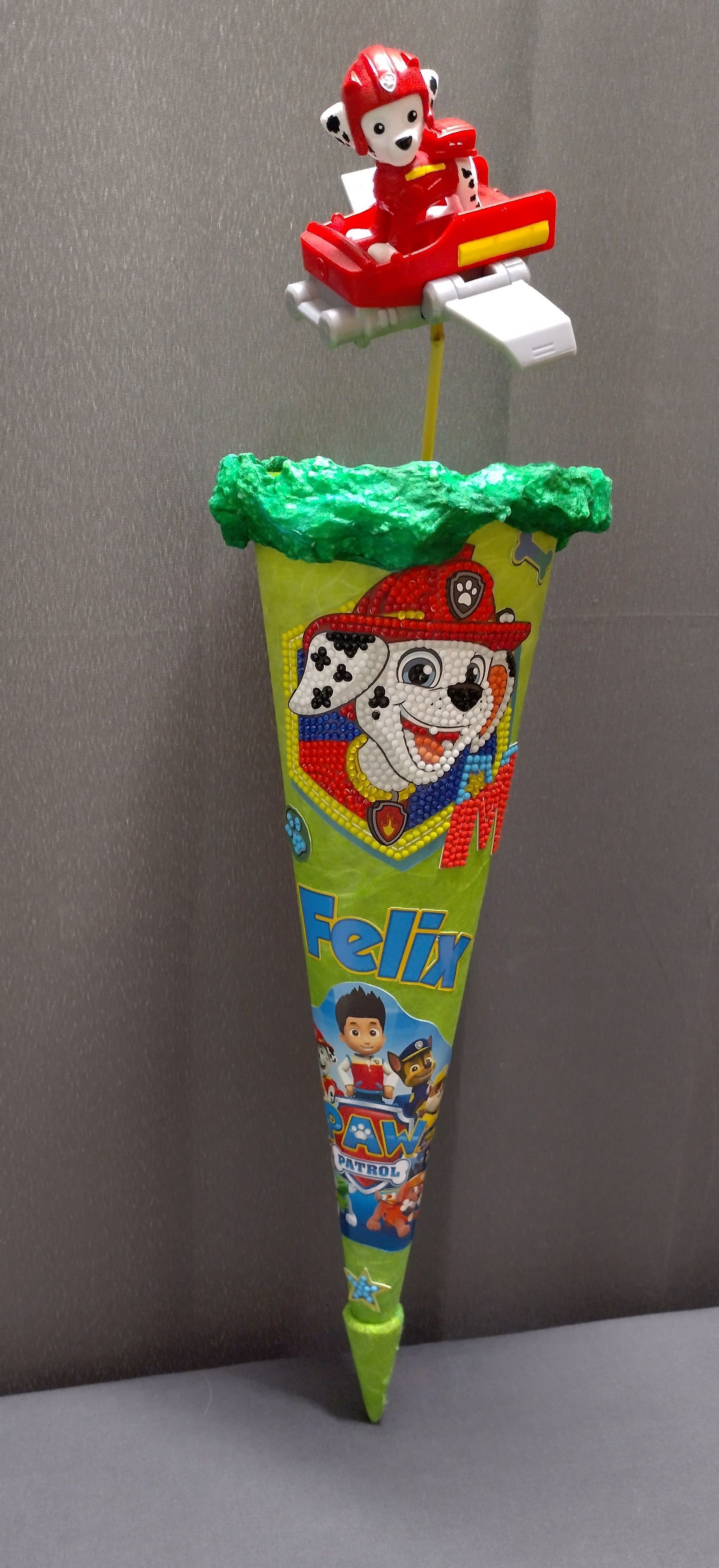 Ein Paw Patrol-Kegel mit einem Spielzeughund oben drauf.