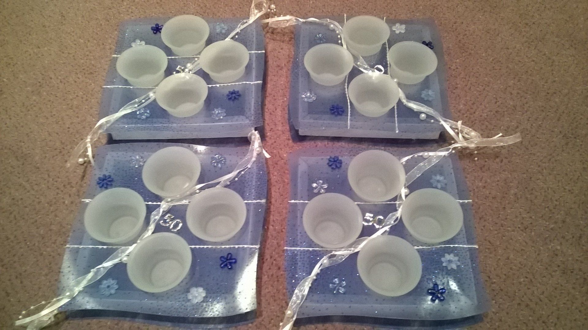 Vier Plastikstücke mit weißen Bechern darauf und der Zahl 50 darauf