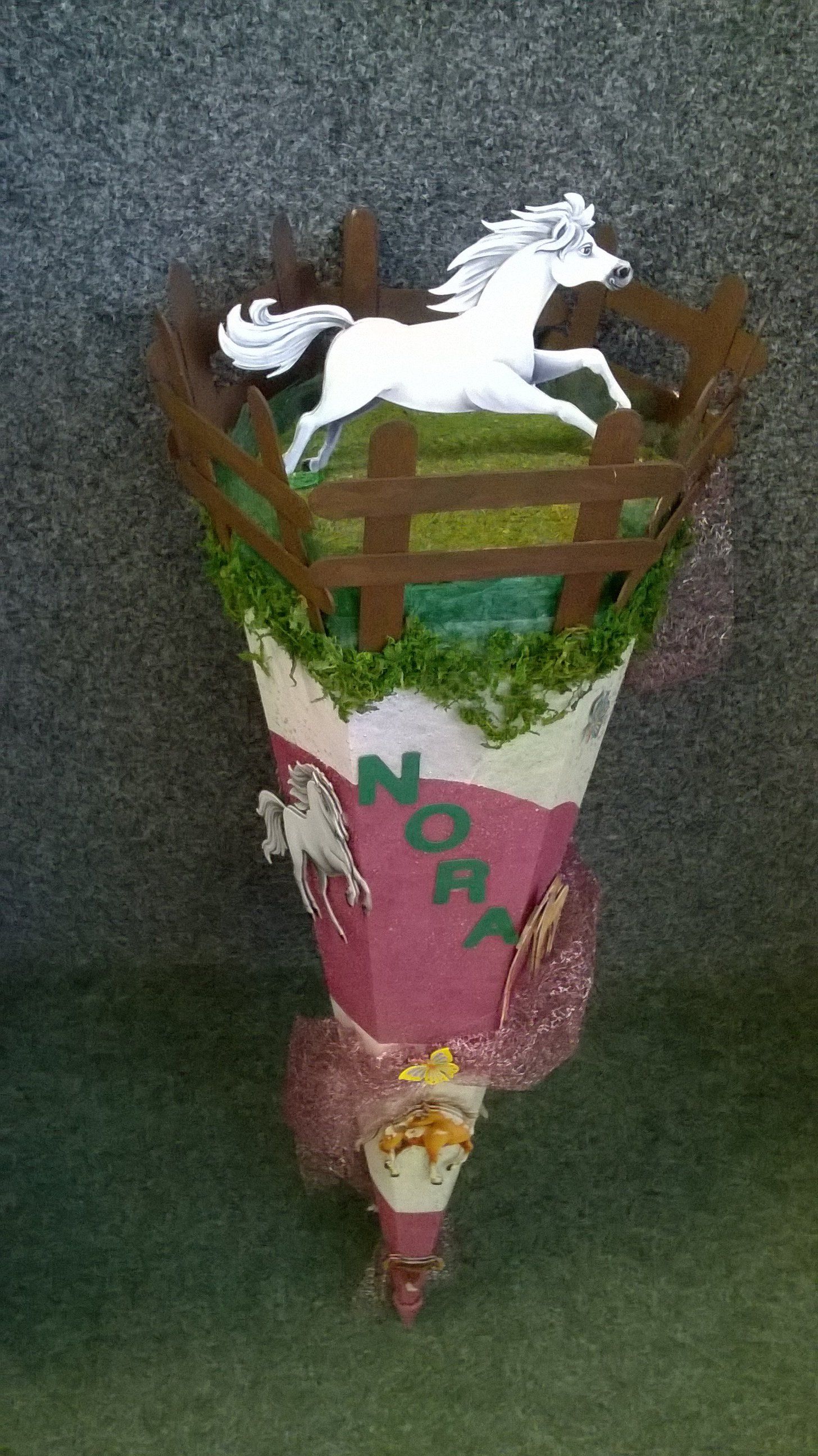 Ein Kegel mit einem Pferd und einem Zaun darauf.