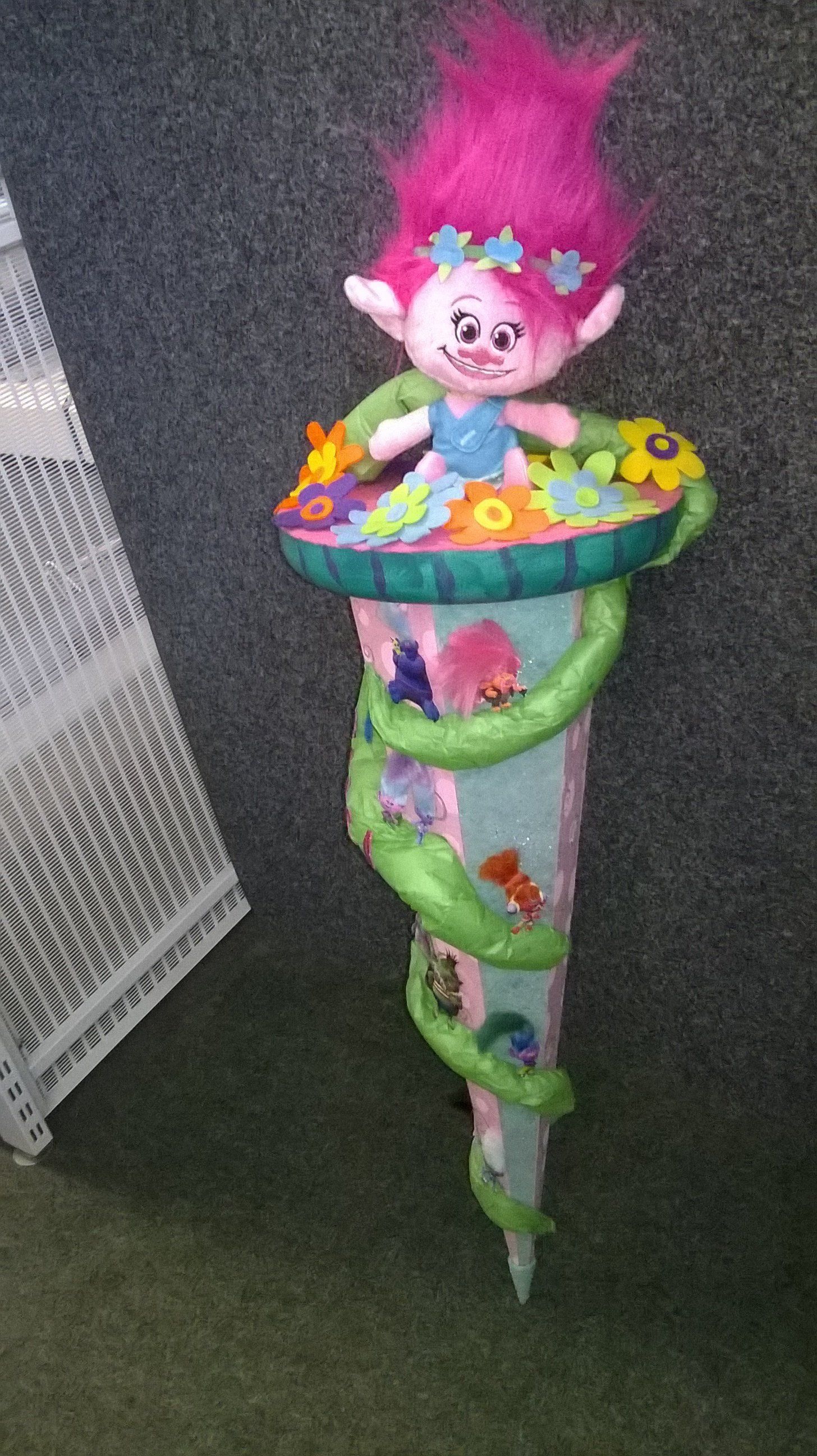 Eine Trollpuppe sitzt auf einem Kegel.