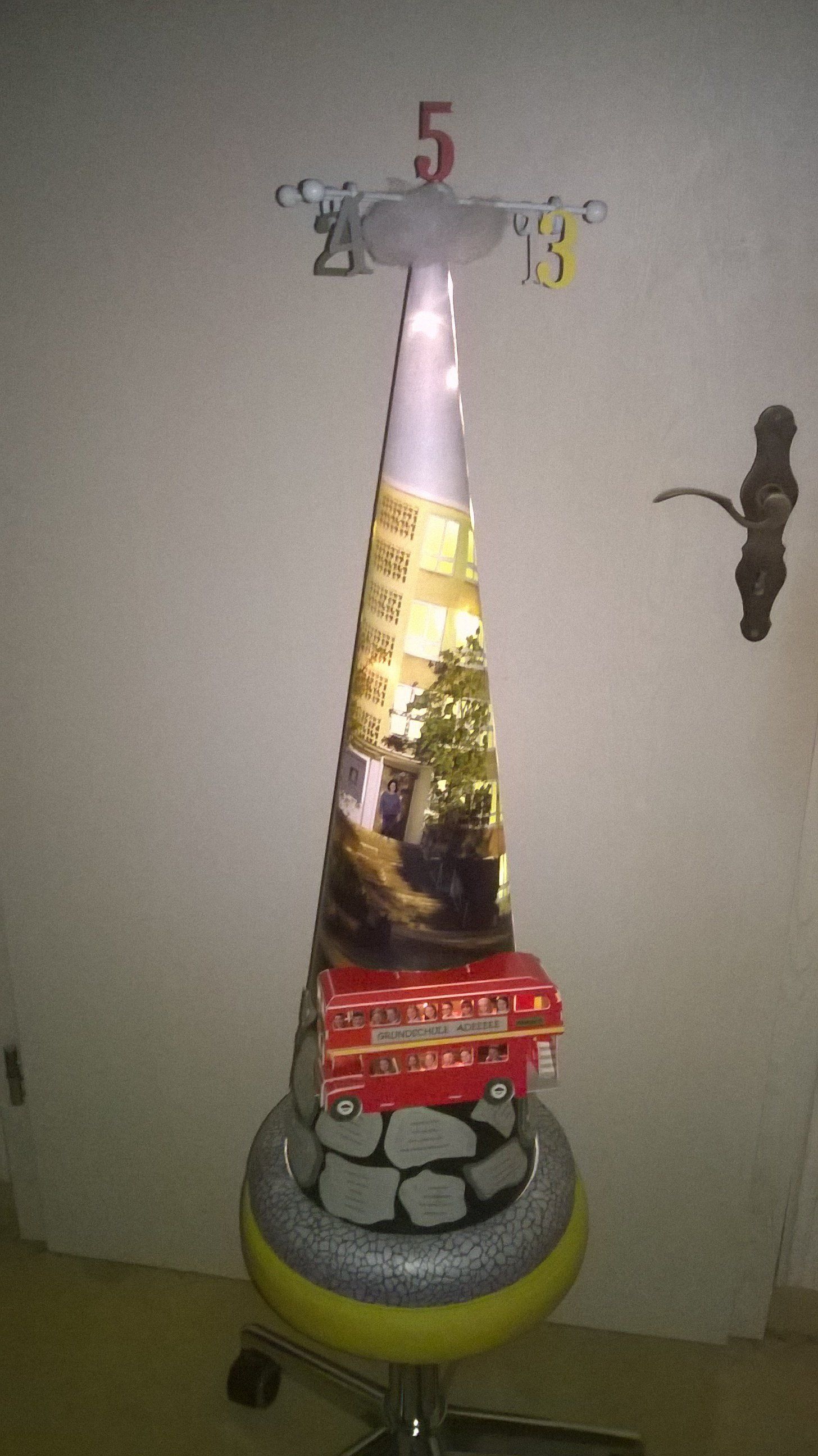 Auf einem Hocker steht ein aus einem Reifen gefertigter Weihnachtsbaum.