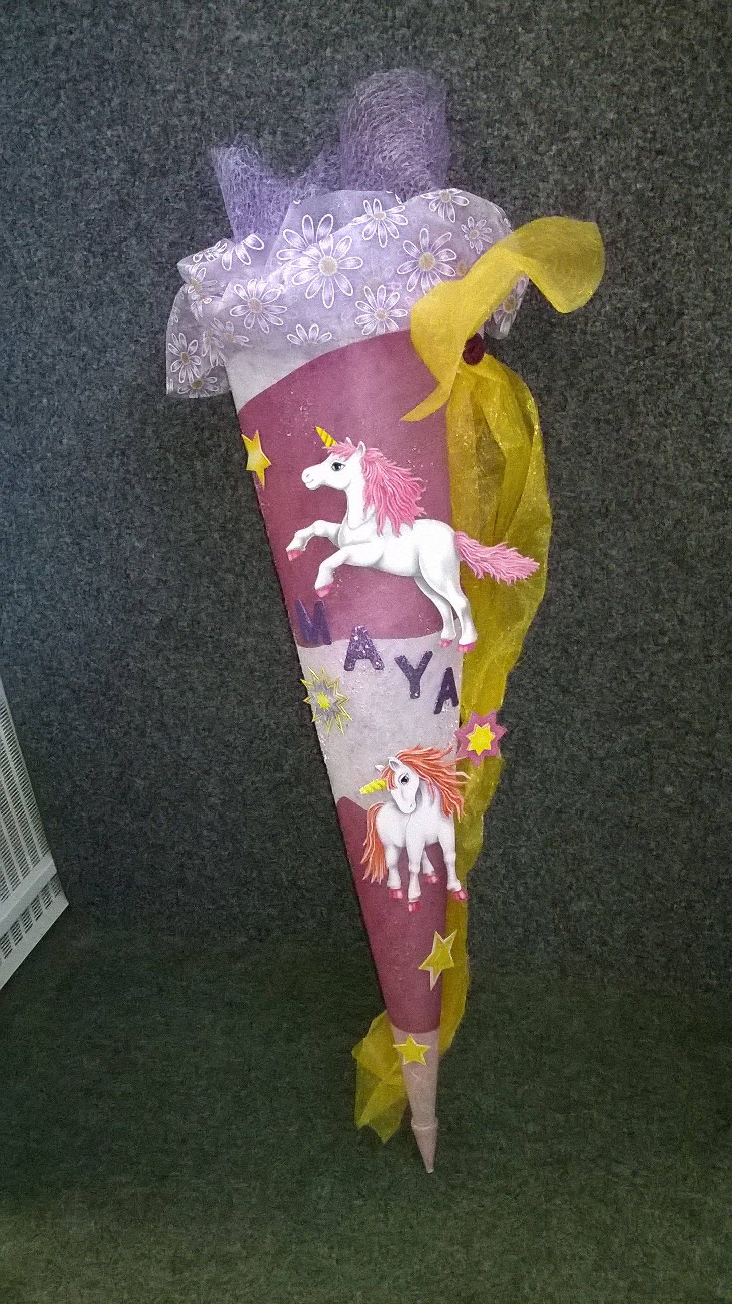 Auf einem Teppich steht ein Kegel mit Einhörnern darauf.