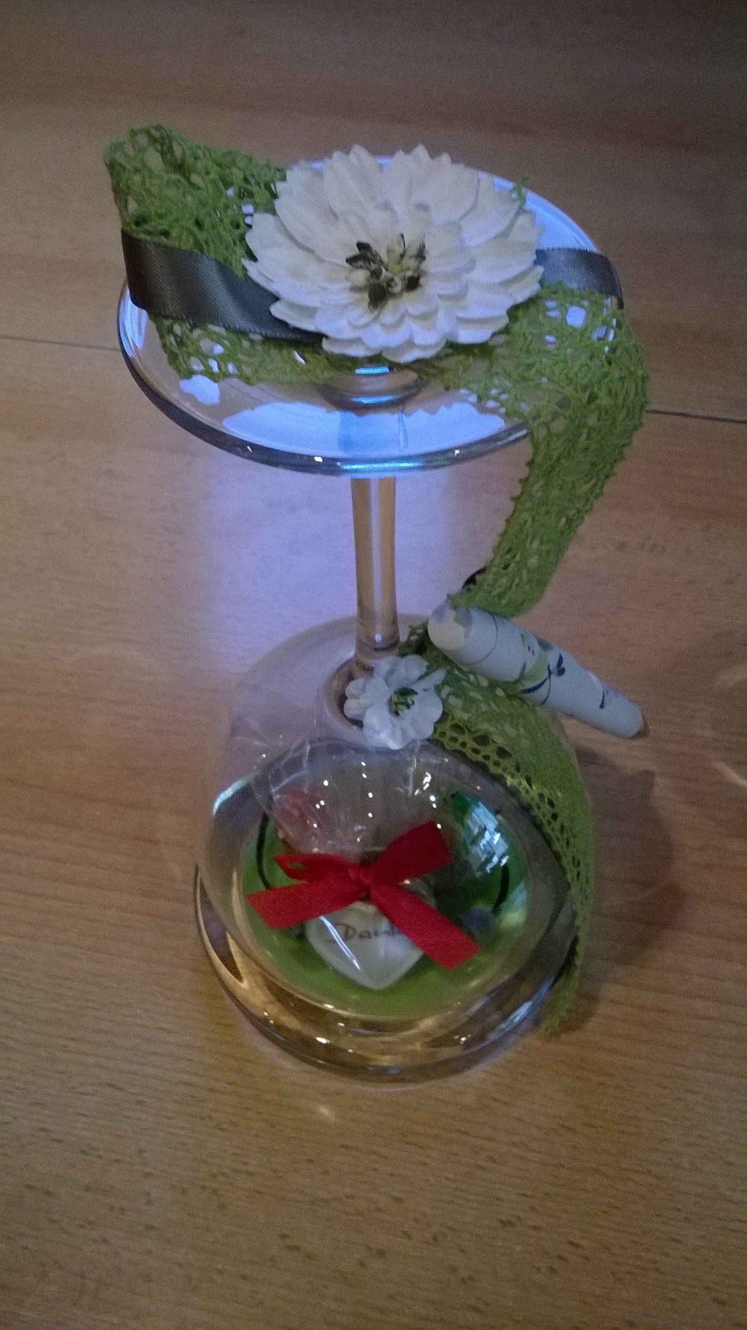 Ein Weinglas mit einer Blume darauf.