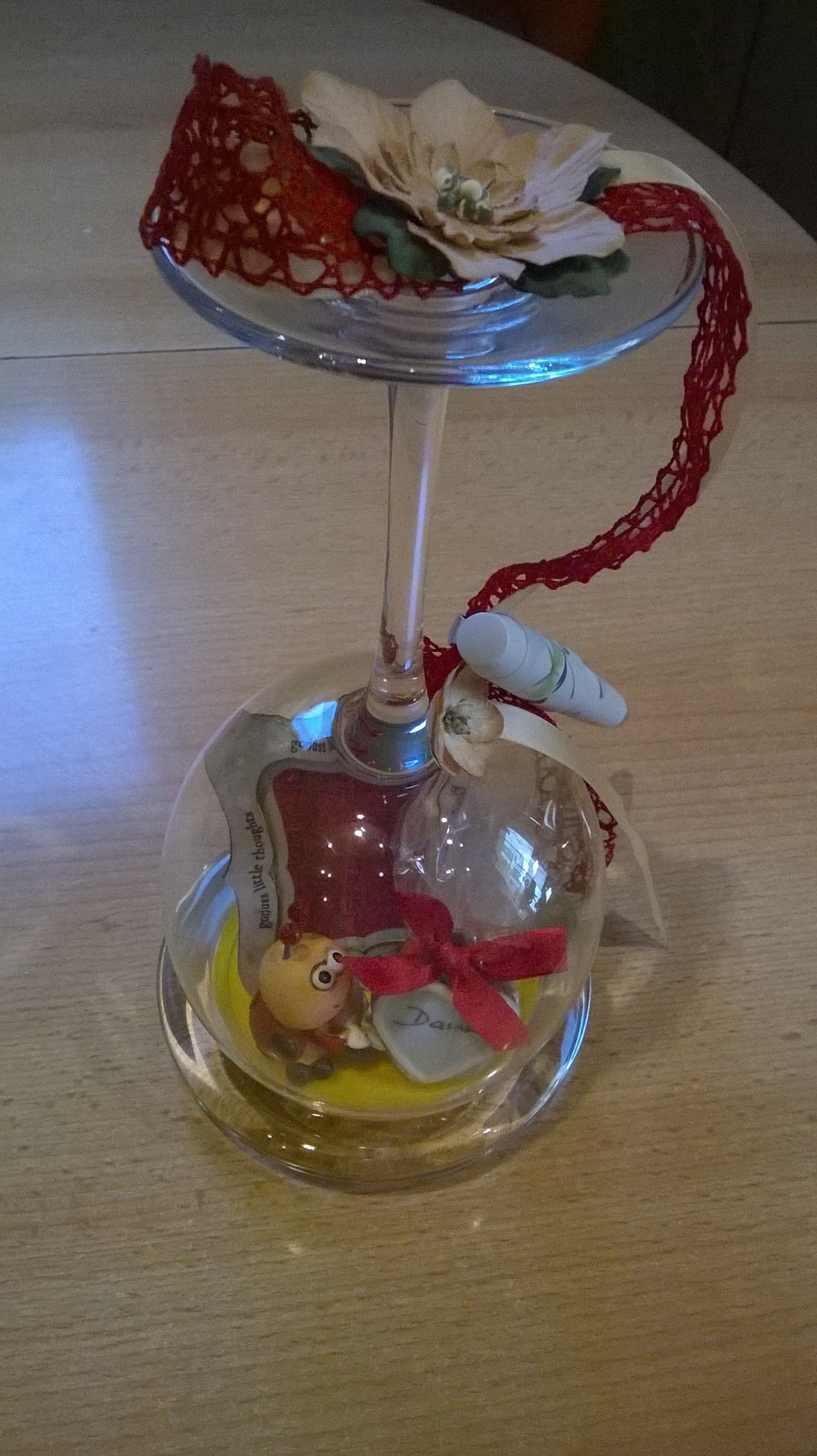 Auf einem Tisch steht ein Weinglas mit einer Blume darin.