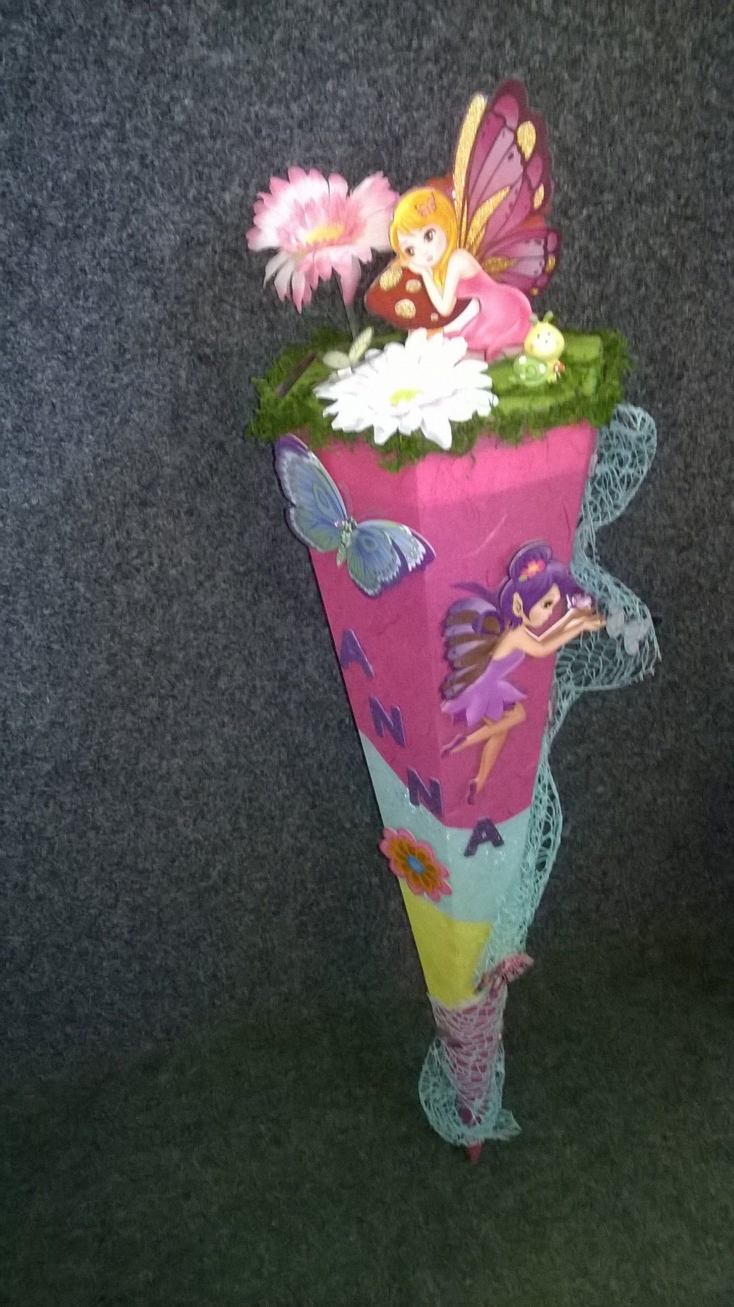 Ein rosa Kegel mit Blumen und Schmetterlingen darauf