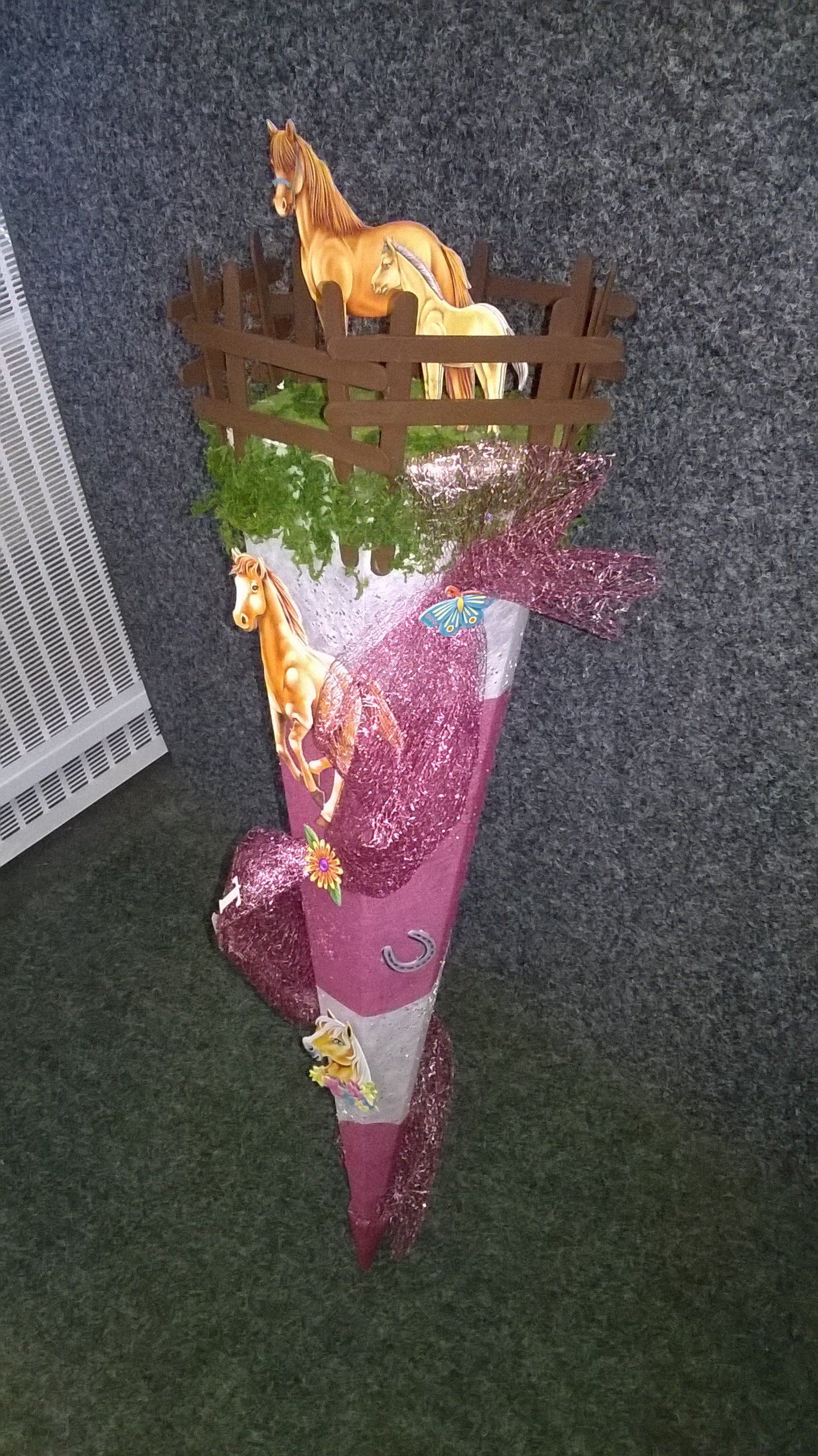 Ein mit Luftballons gefüllter Kegel und eine Giraffe in einem Zaun.