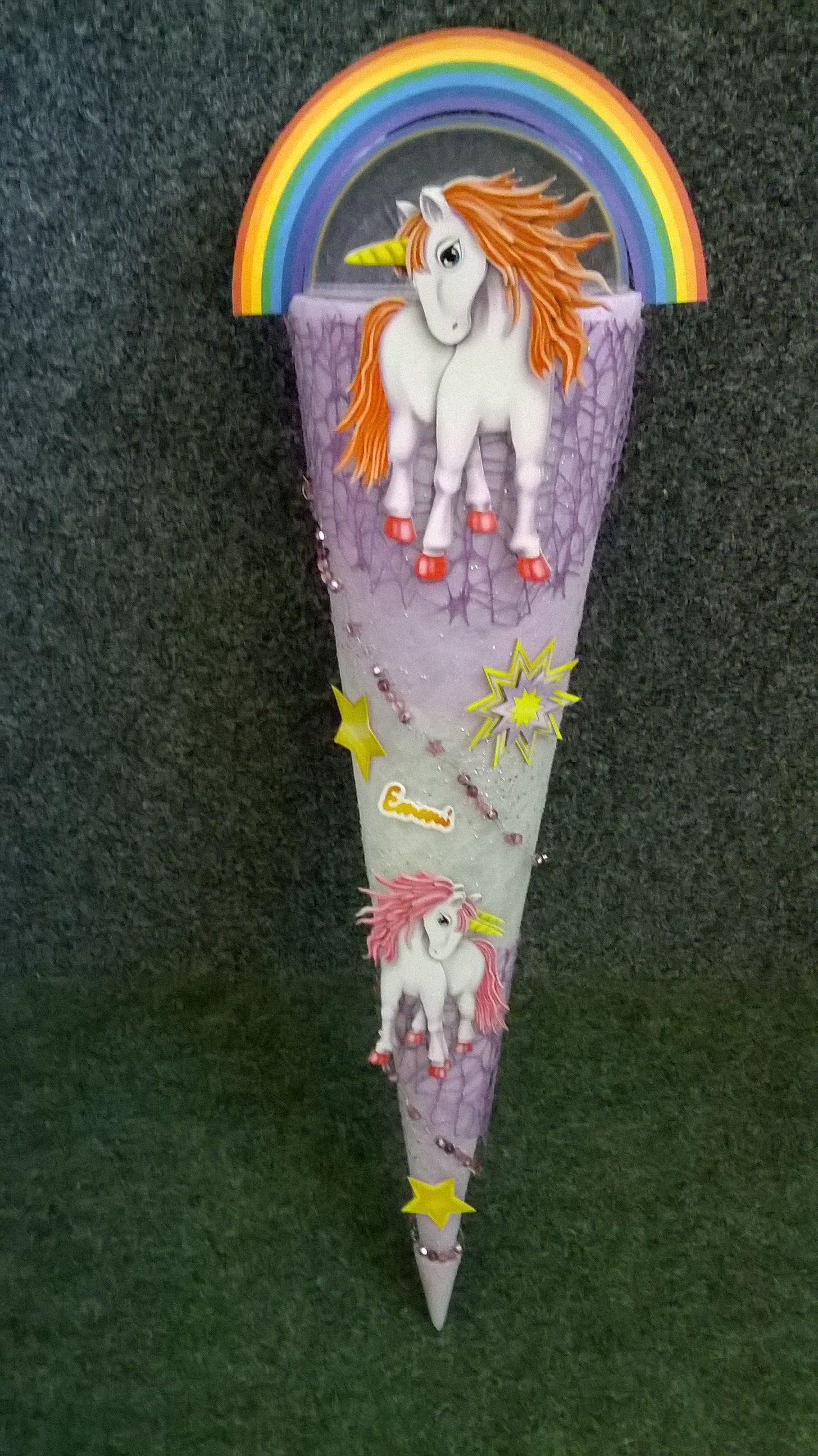 Ein lila Kegel mit einem Einhorn und einem Regenbogen darauf.