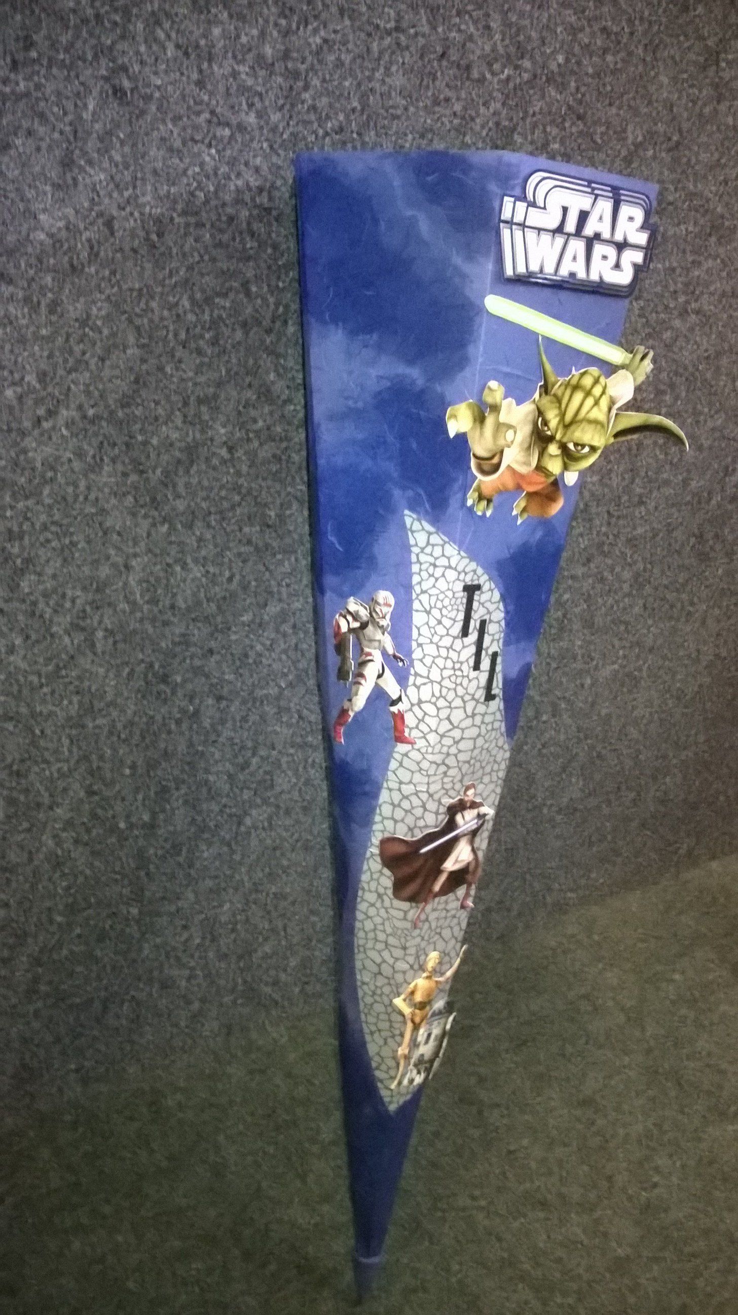 Ein Star Wars-Regenschirm liegt auf einem Teppichboden.