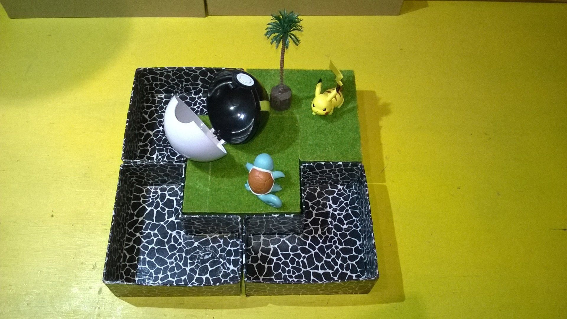 Eine Spielzeugschildkröte sitzt auf einem Tisch neben einem zerbrochenen Ei