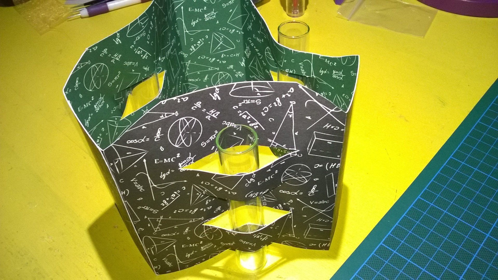 Auf einem gelben Tisch liegt ein Blatt Papier mit mathematischen Gleichungen.