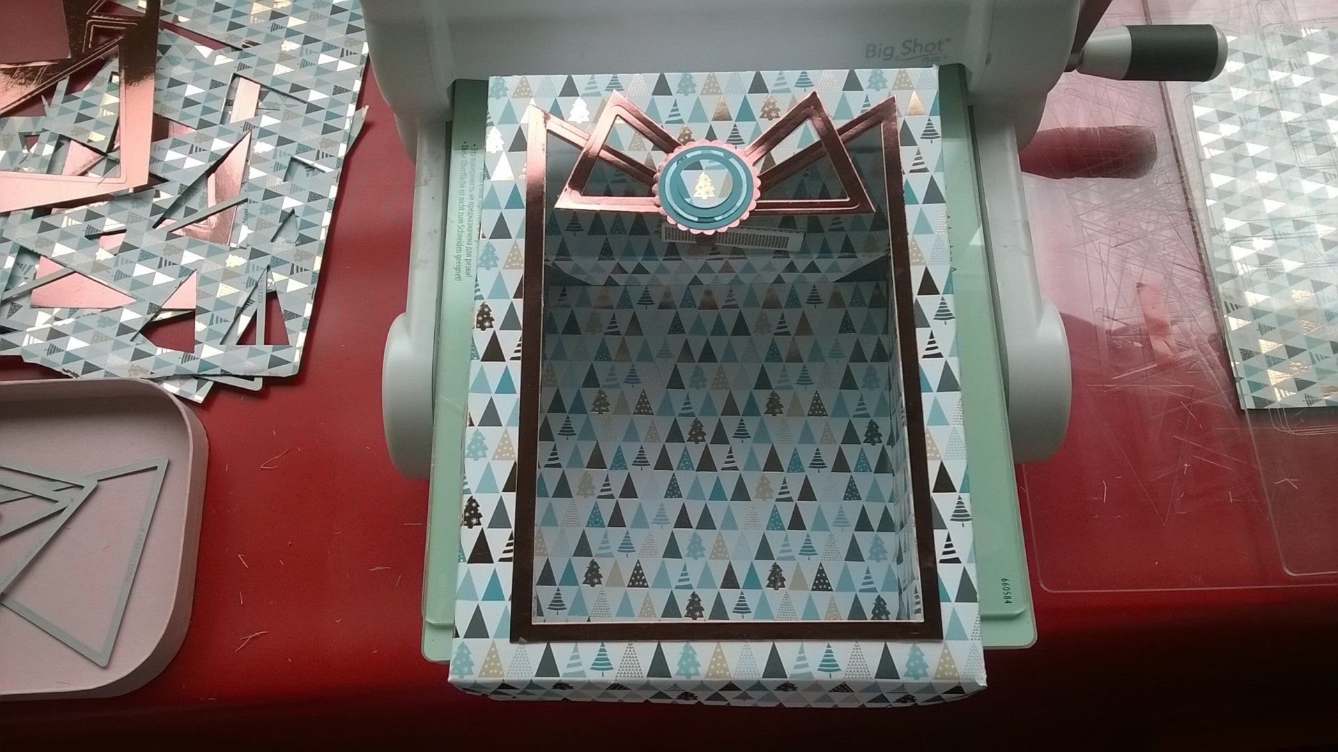 Eine Maschine schneidet ein Stück Papier mit Dreiecken darauf