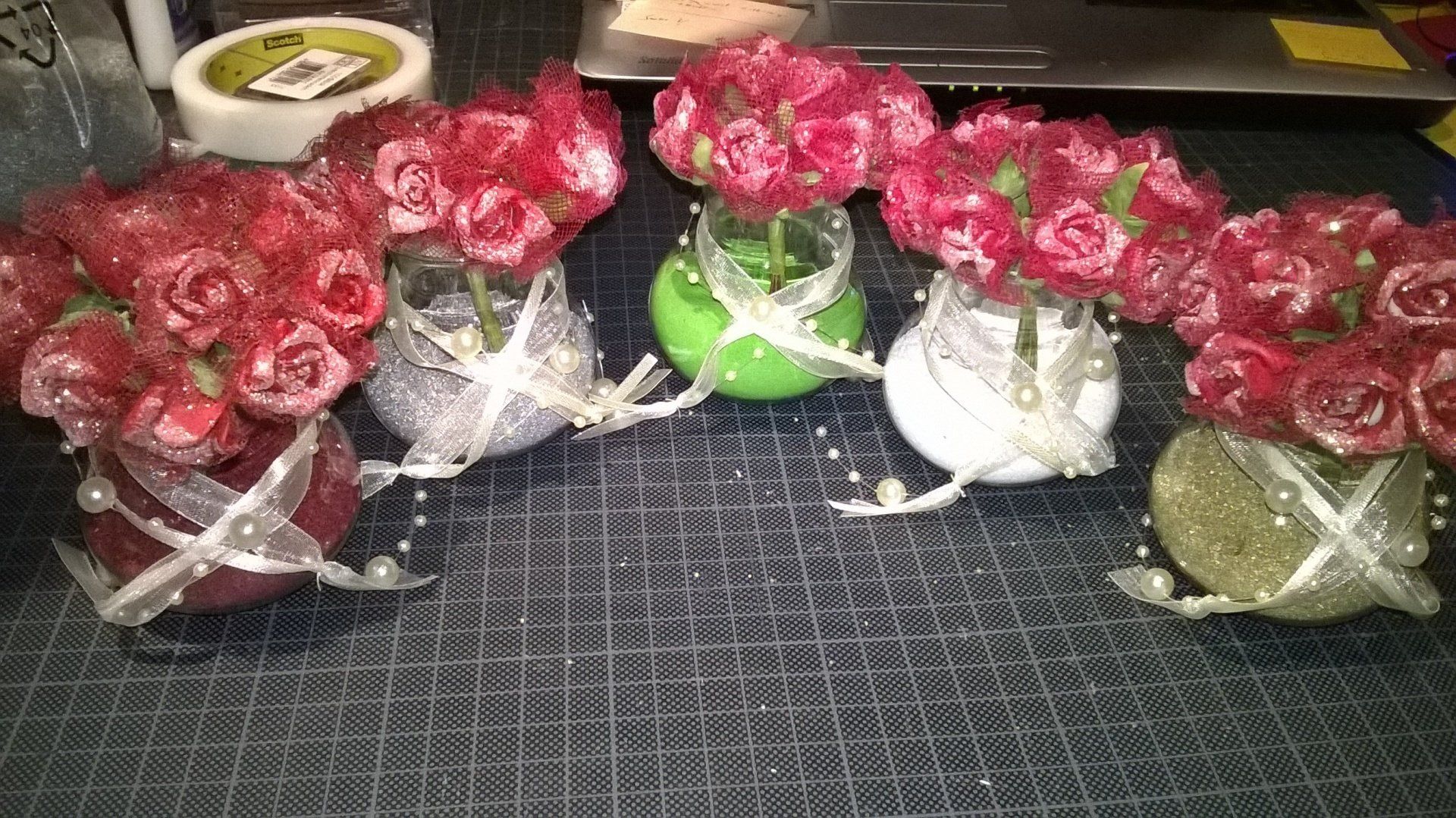 Ein paar Vasen mit Blumen darin auf einem Tisch