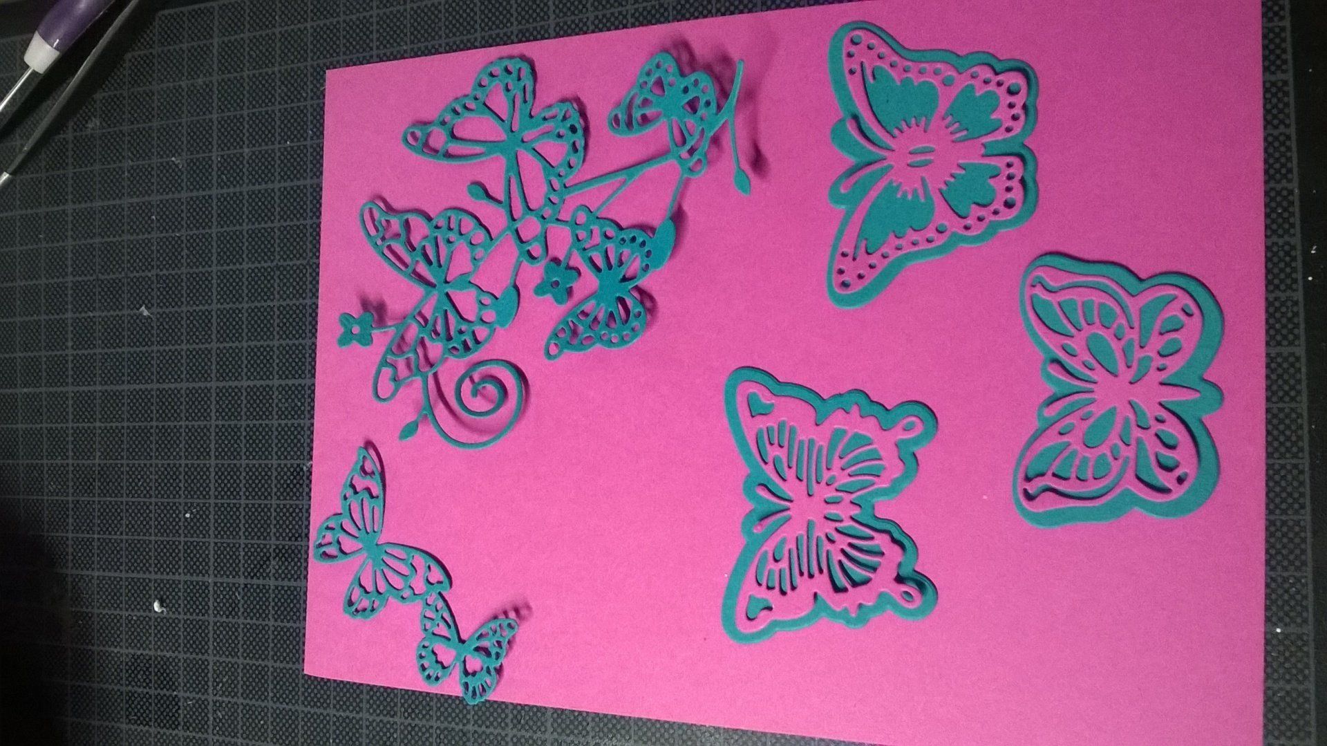 Ein rosa Blatt Papier mit blauen Schmetterlingen darauf