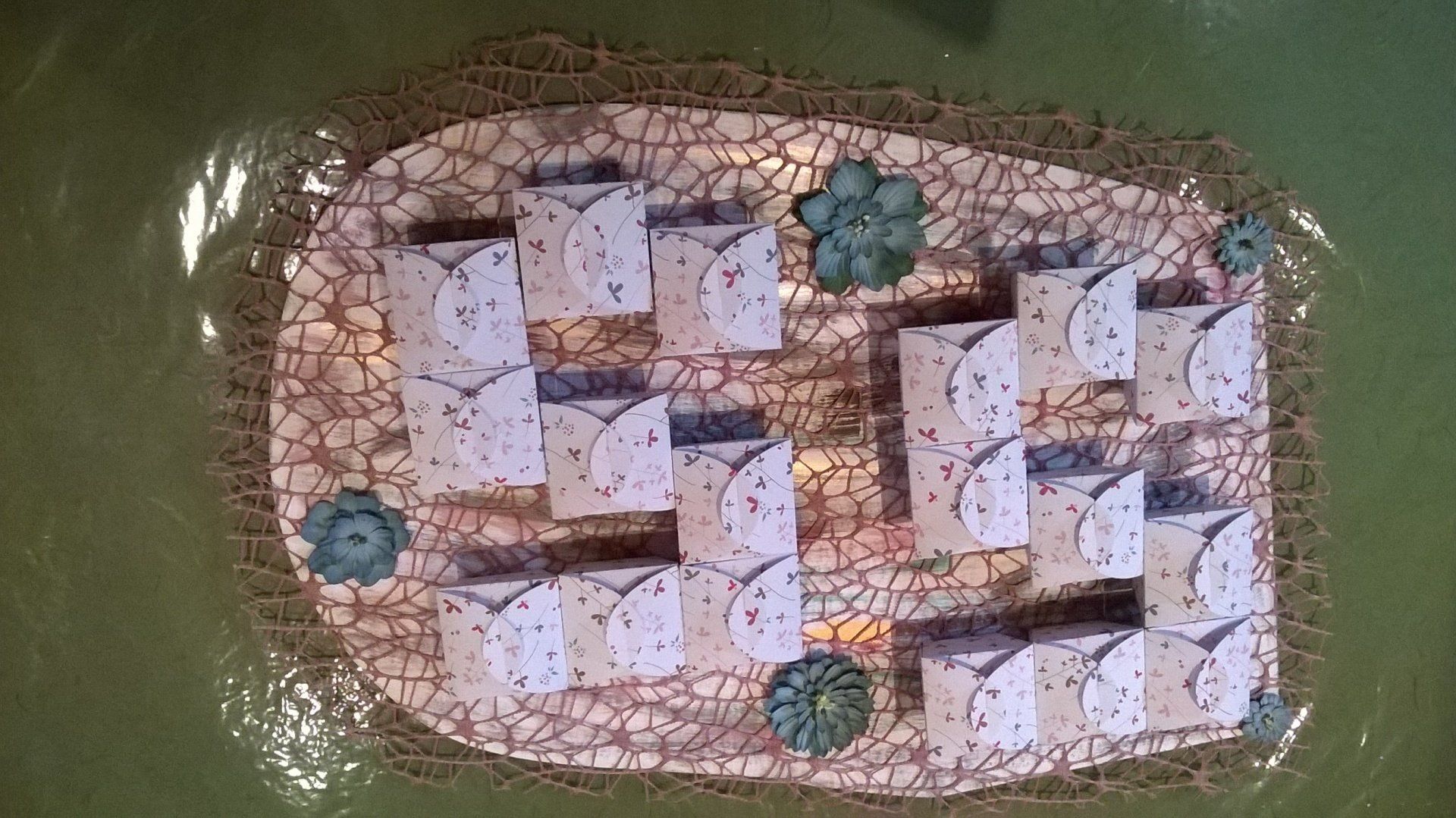 Ein Blatt Papier mit Blumen darauf schwimmt auf einer grünen Oberfläche.