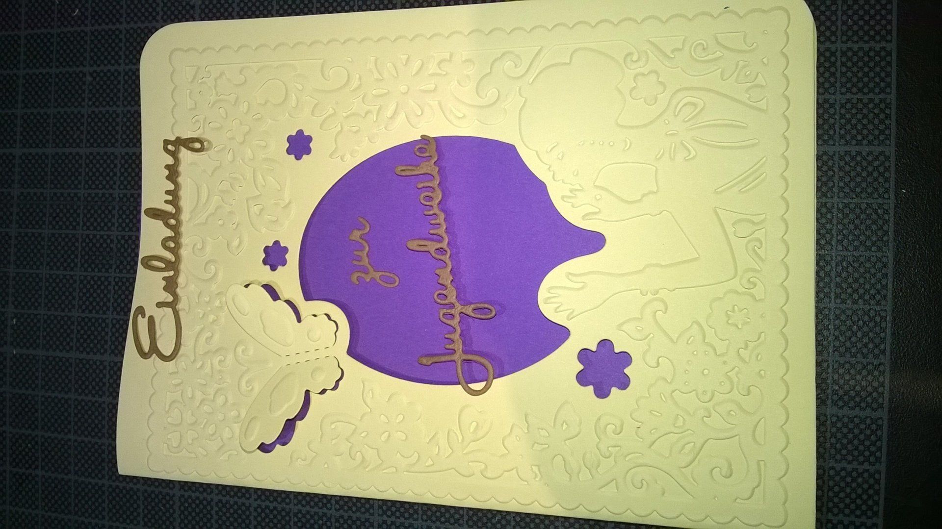 Eine violett-weiße Karte mit der Aufschrift „Einladung“