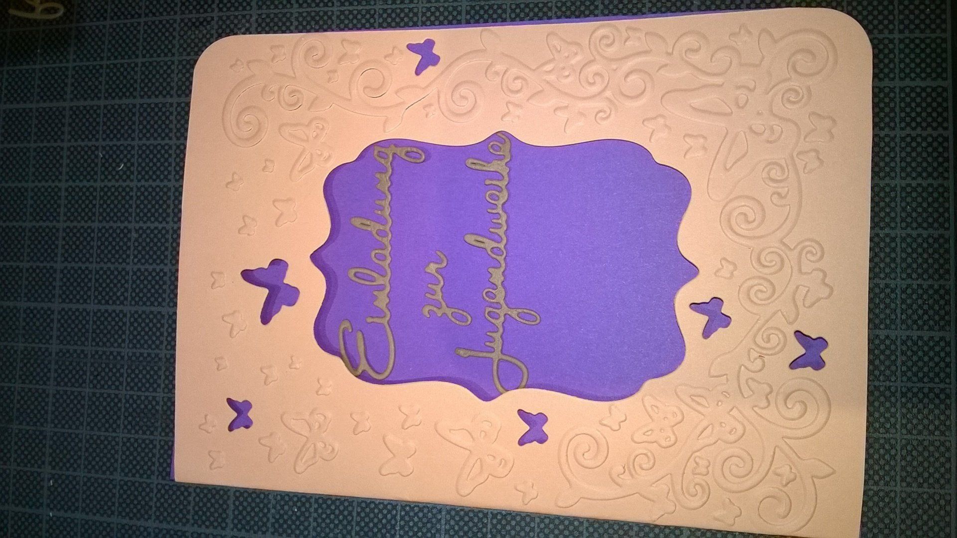 Eine Karte mit einem lila Rahmen und Schmetterlingen darauf