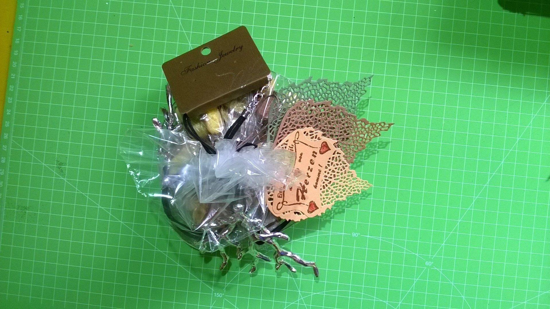 Auf einem grünen Tisch steht eine kleine Schachtel mit einem Herz darauf.