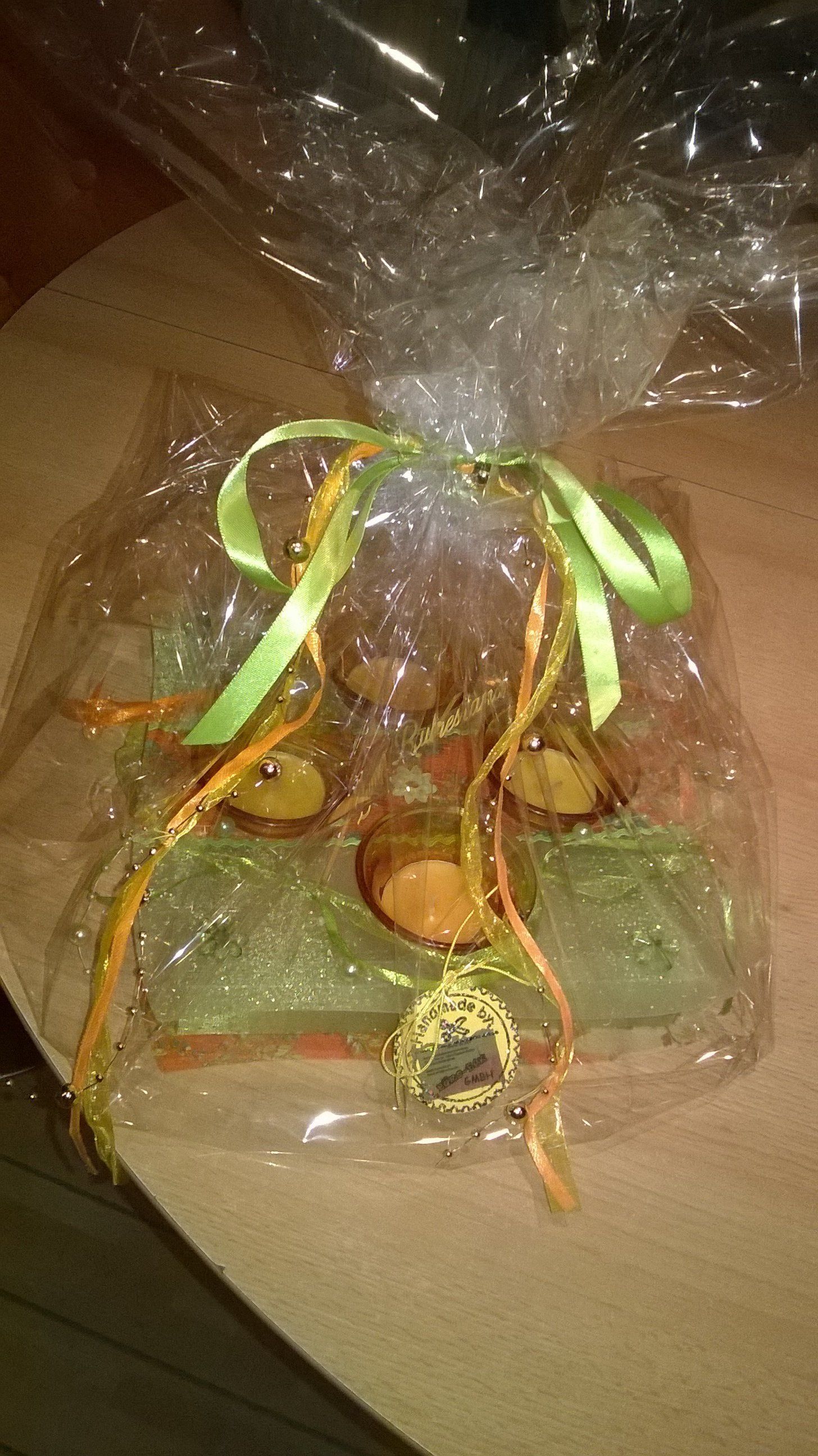 Eine Plastiktüte gefüllt mit einer Kerze und einer grünen Schleife auf einem Tisch.