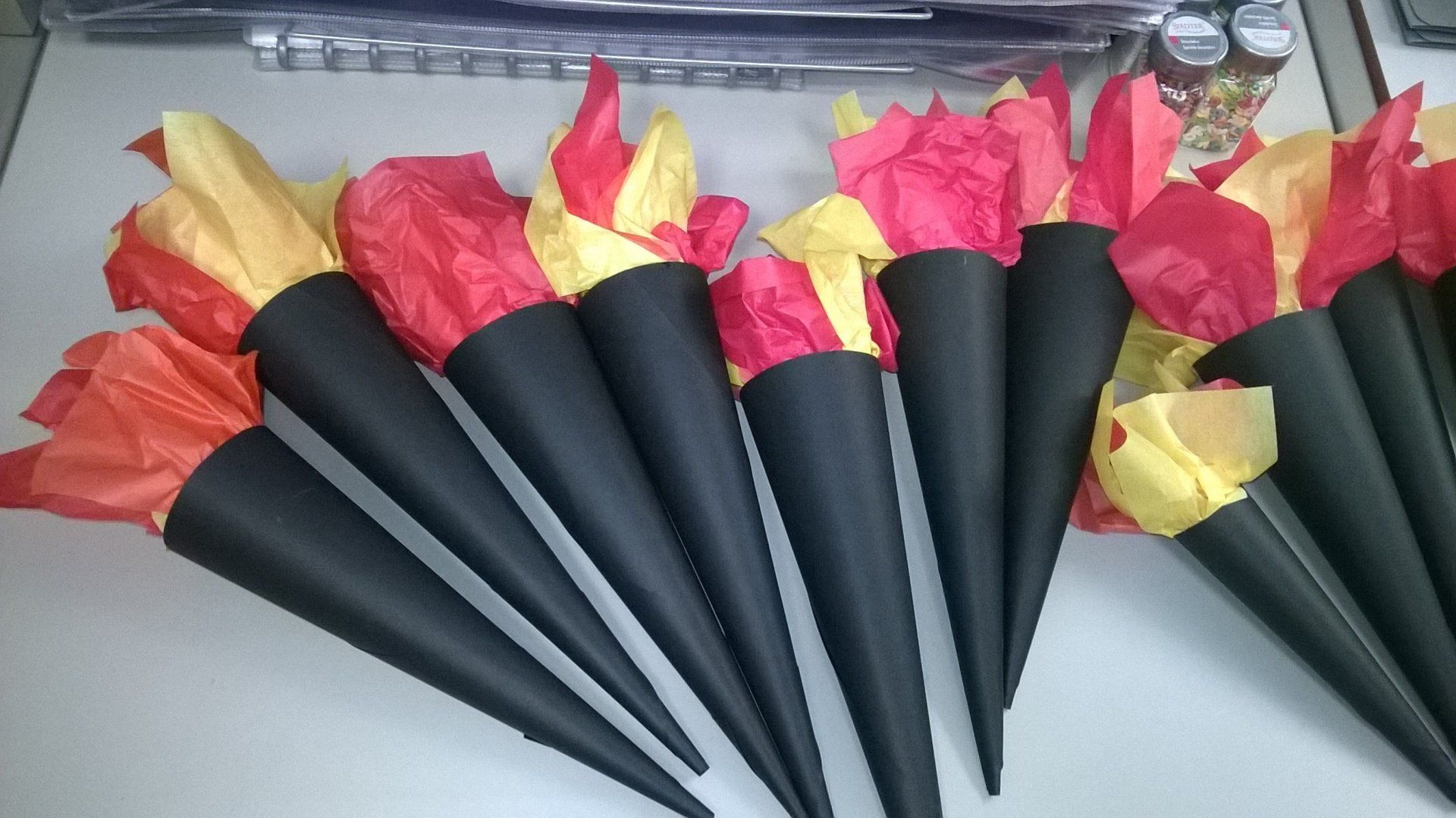 Ein Bündel schwarzer Zapfen, eingewickelt in rotes und gelbes Seidenpapier