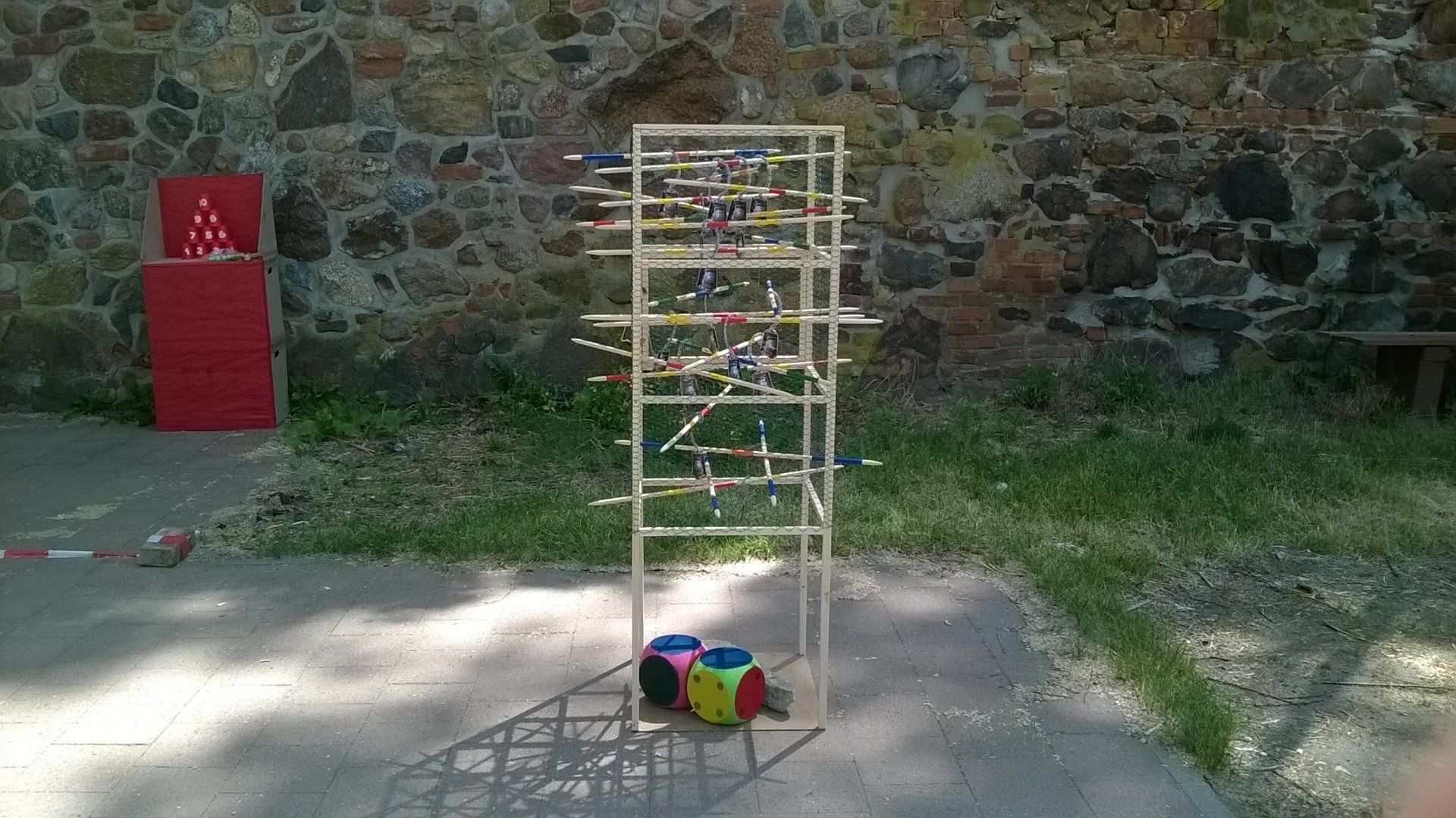 Ein Leiterspiel liegt auf dem Boden vor einer Steinmauer.