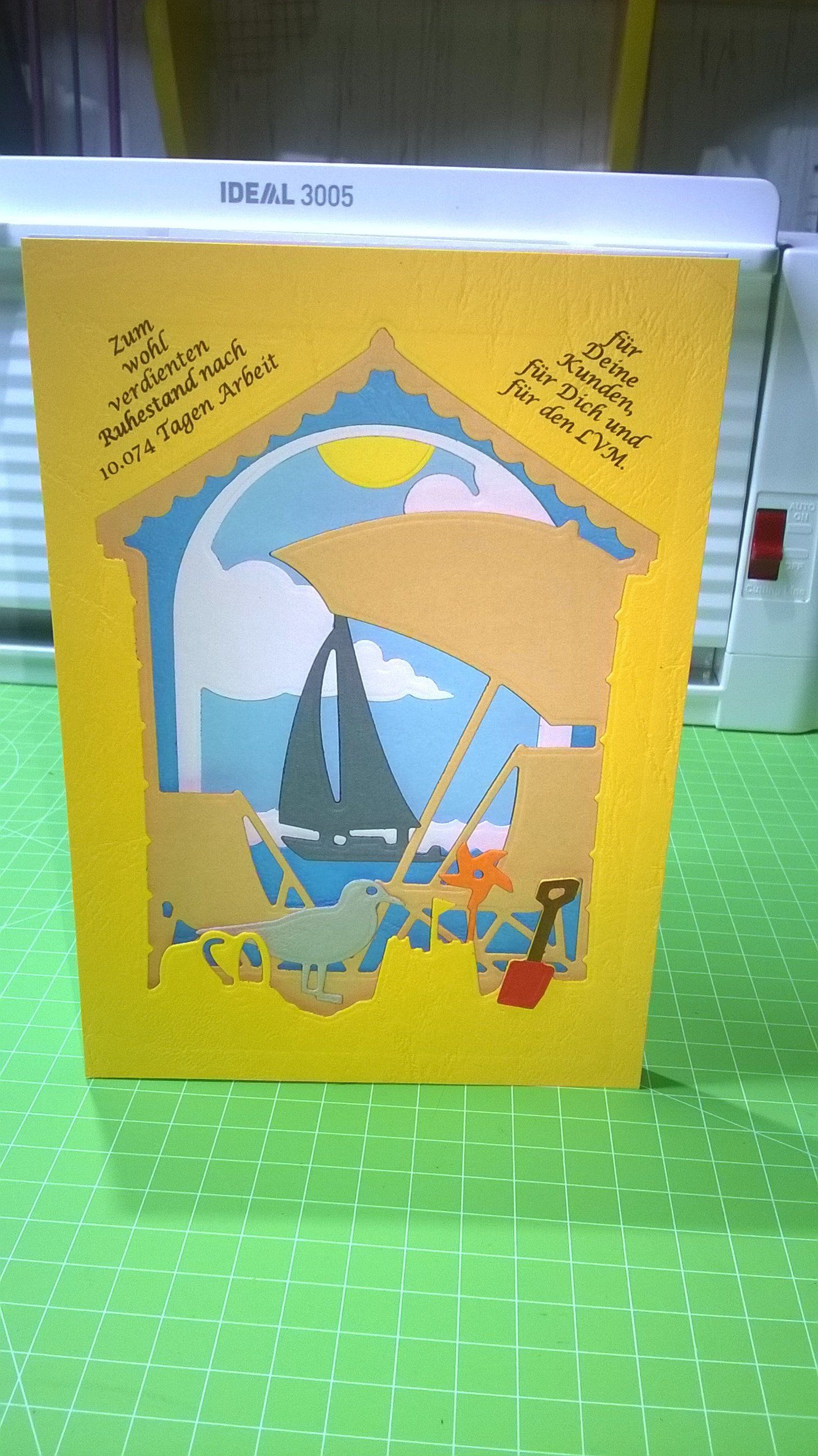 Auf einem grünen Tisch liegt eine gelbe Karte mit einem Segelboot darauf.