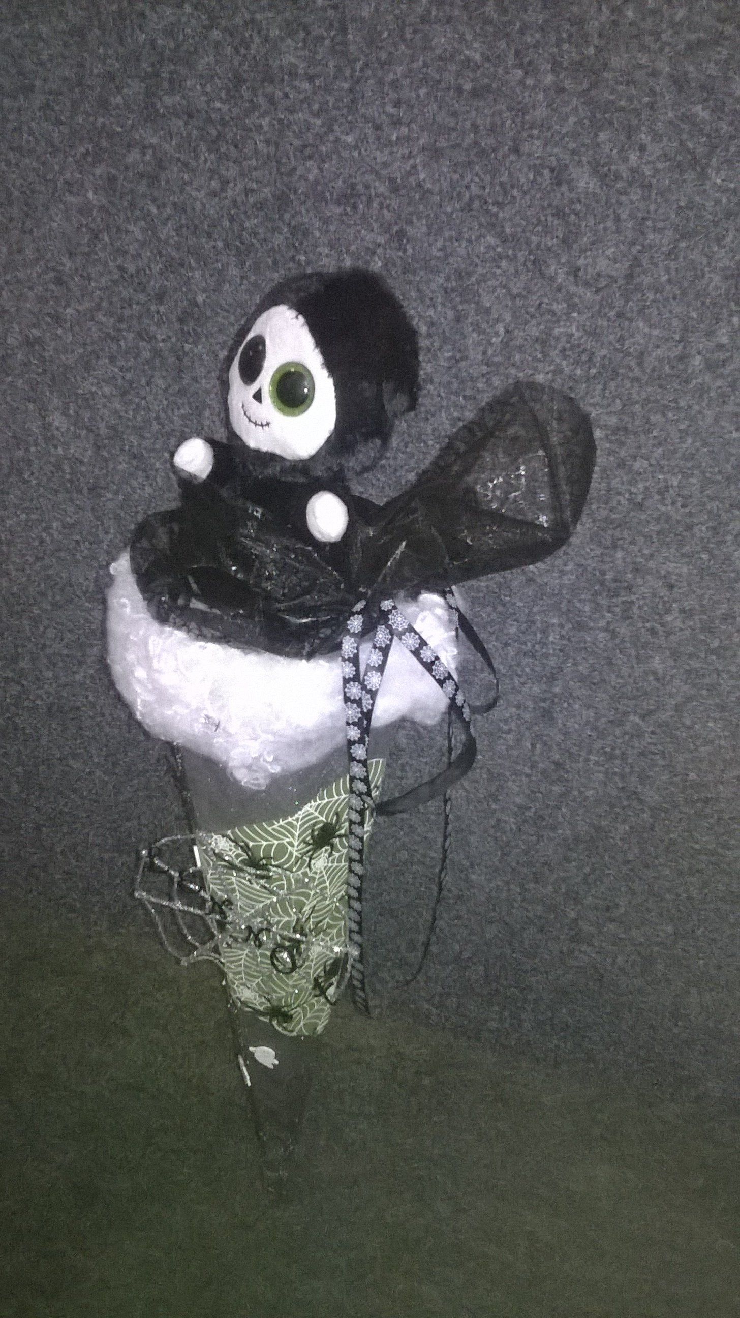 Eine Sensenmann-Puppe sitzt auf einer Wolke.