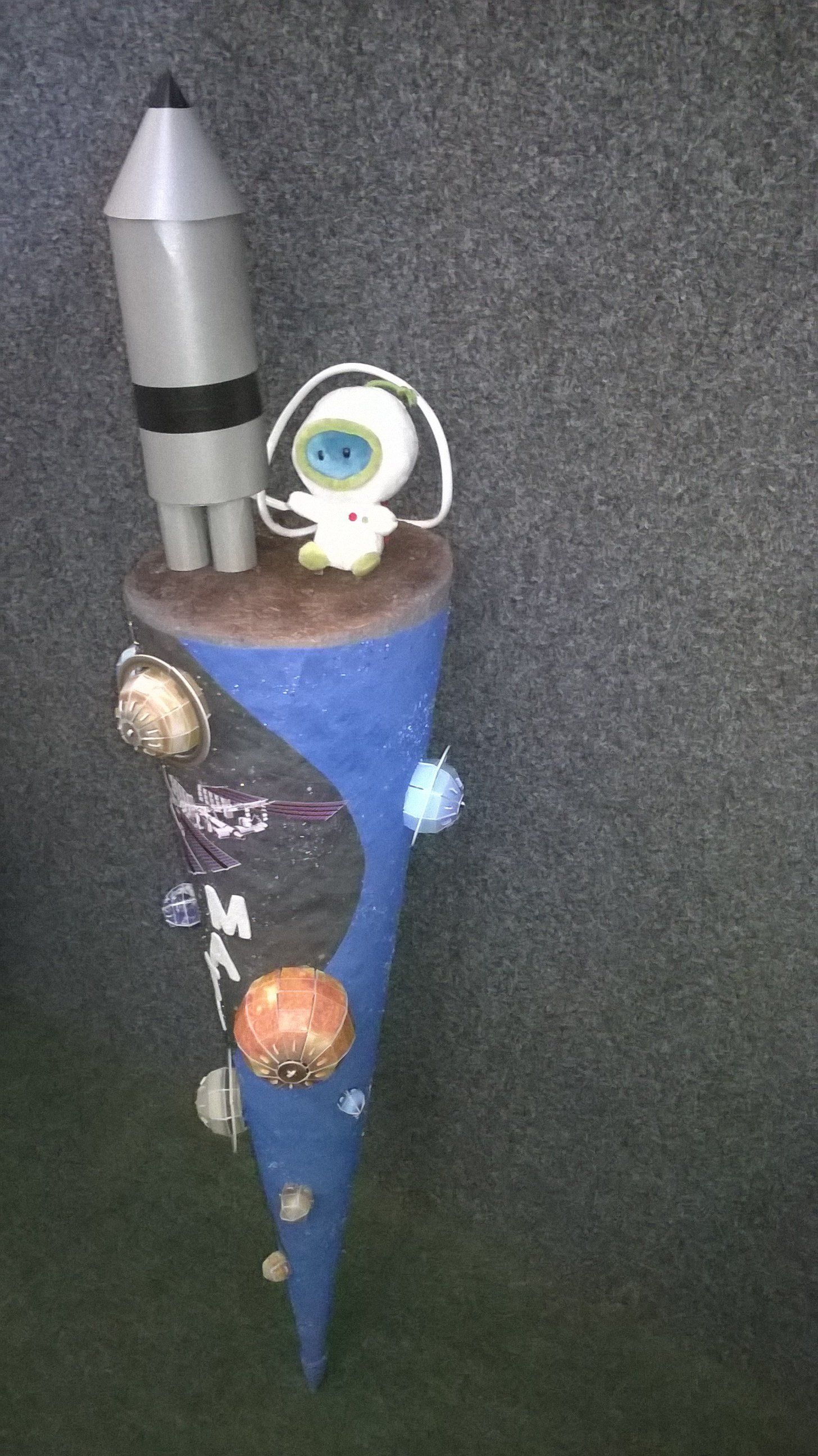 Ein blauer Kegel mit einer Rakete und einem Astronauten darauf.