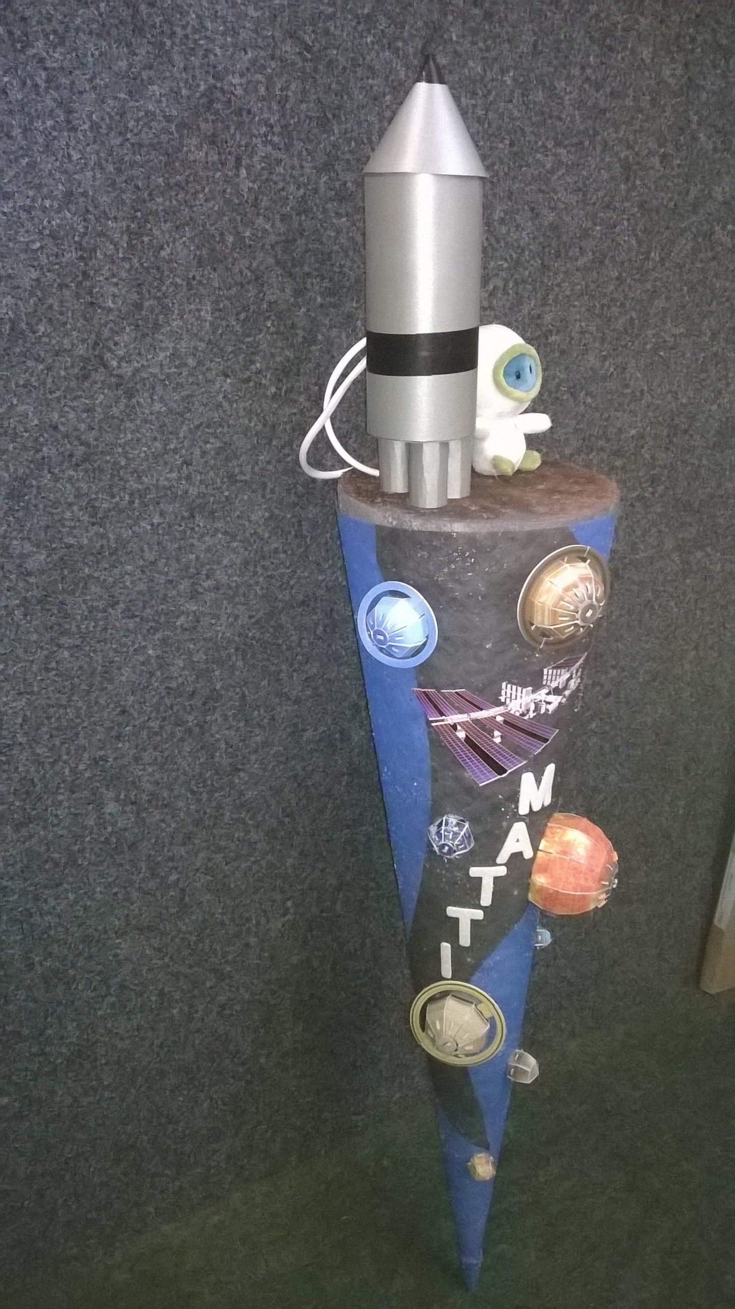 Eine Rakete sitzt auf der Spitze eines blauen Kegels.