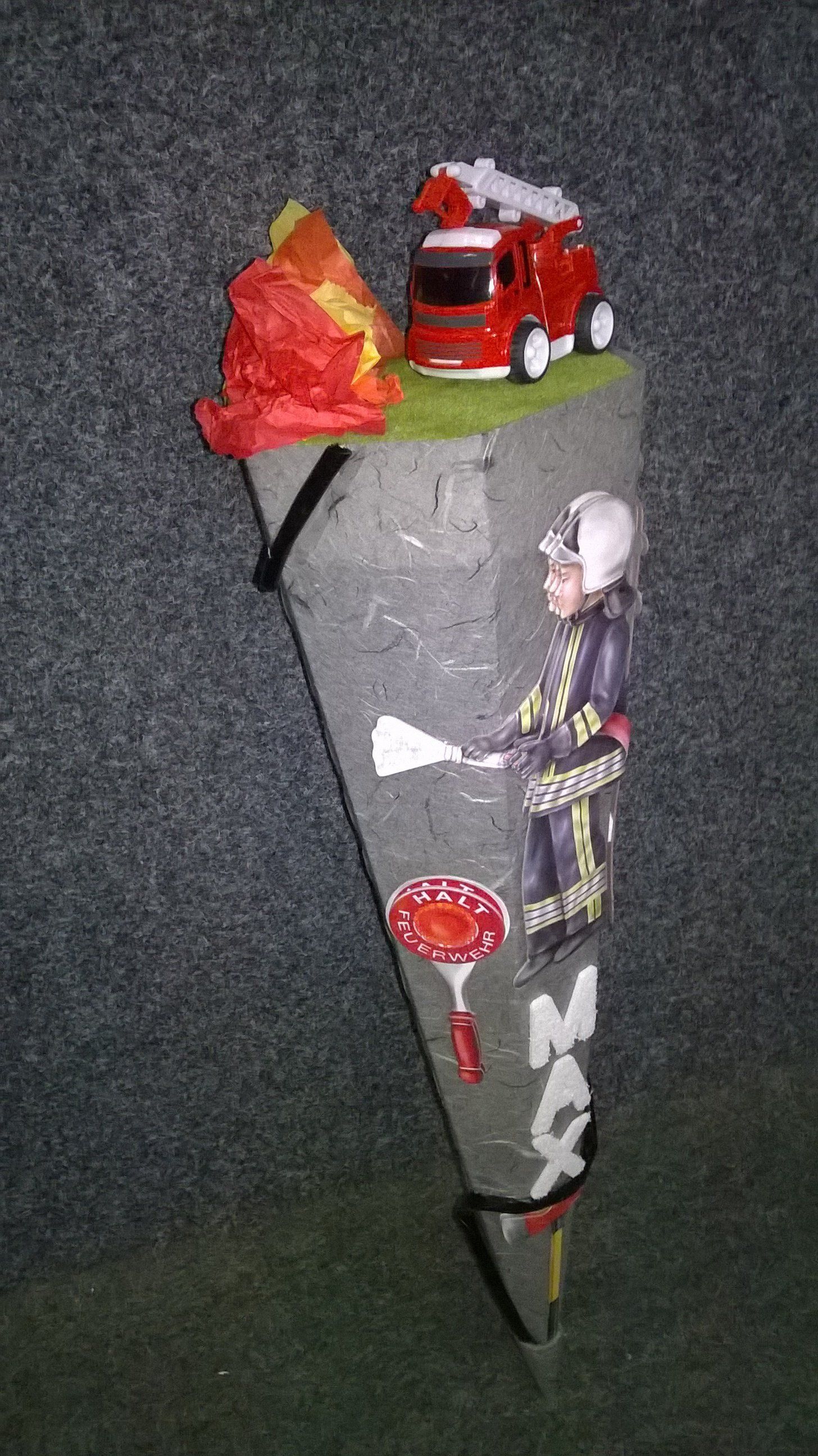 Ein Kegel mit einem Feuerwehrmann und einem Feuerwehrauto darauf.