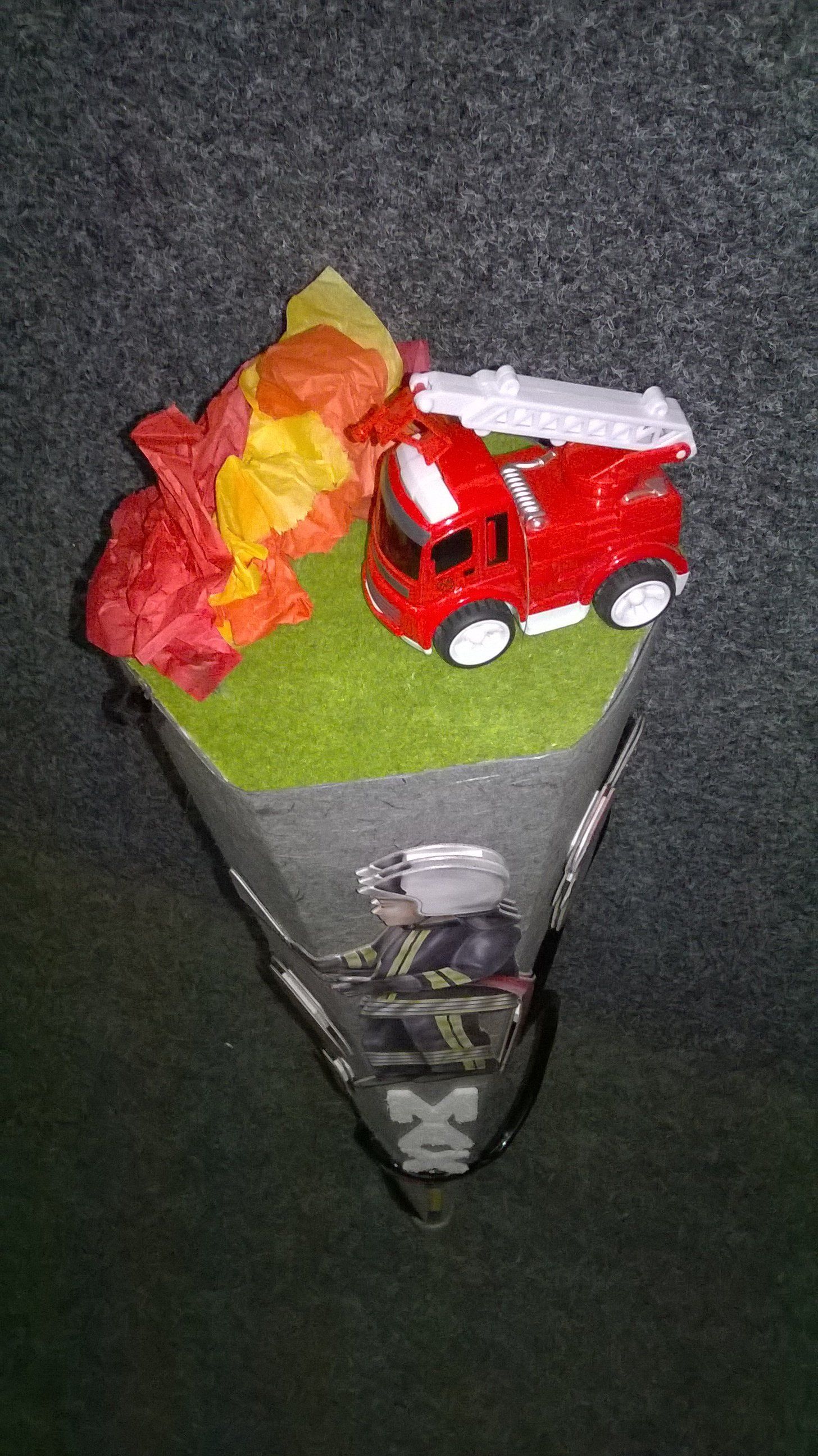 Ein Spielzeug-Feuerwehrauto steht auf einem Kegel.