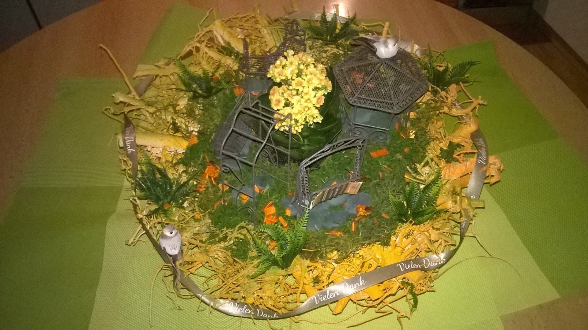 Ein Teller mit Essen, Blumen und Kerzen auf einem Tisch.