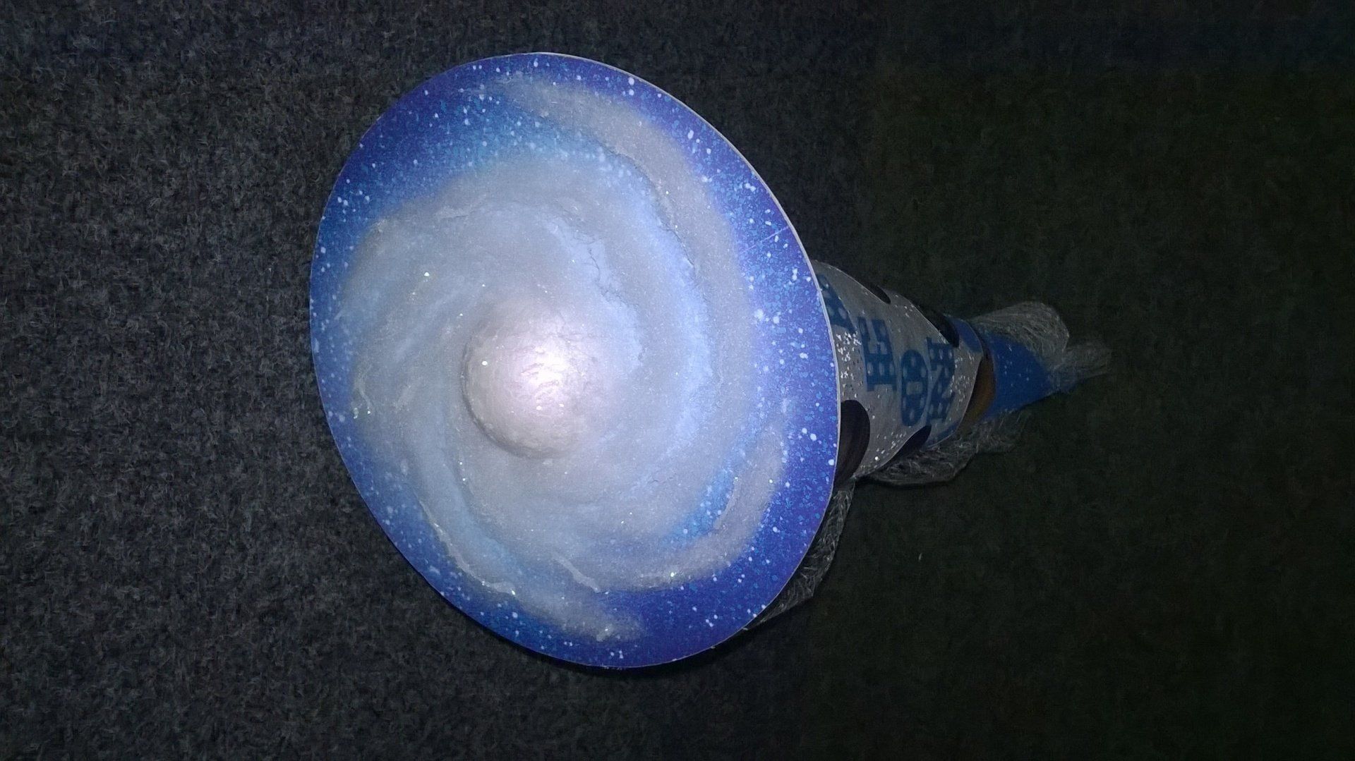 Auf einer schwarzen Oberfläche befindet sich ein blau-weißer Kreis mit einer Spirale darauf.